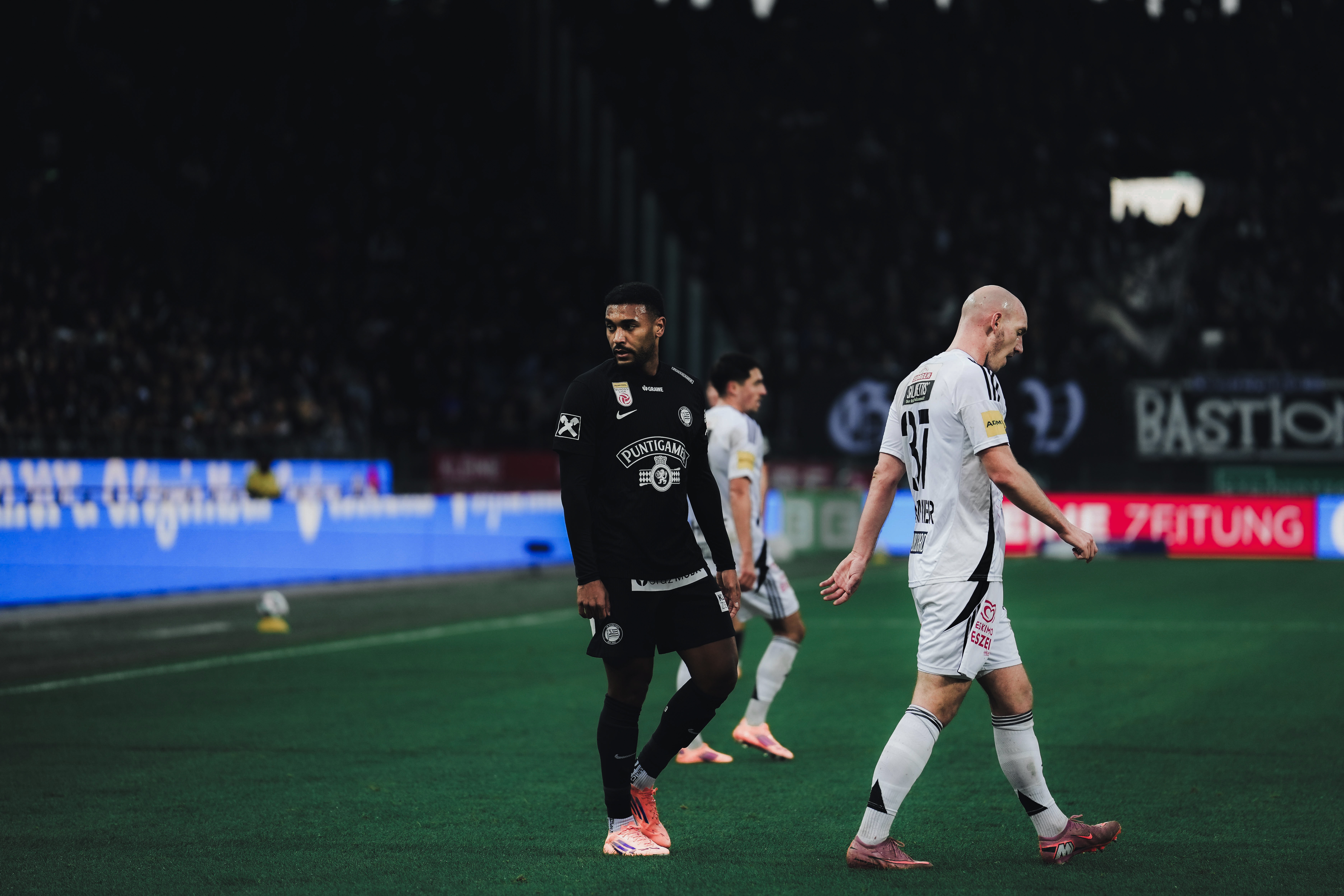 Zwei Spieler gehen am Rasen spazieren.