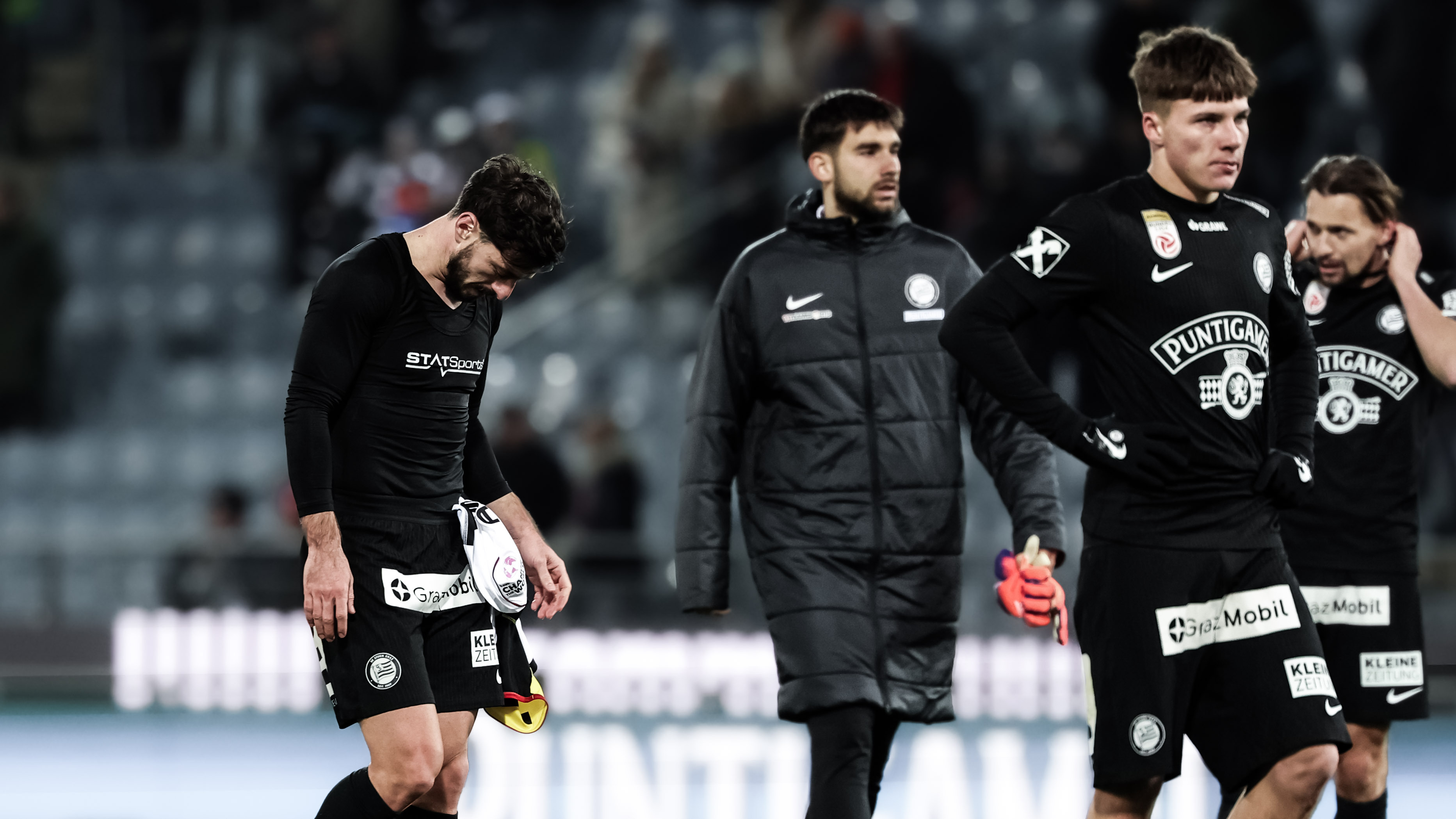 vier traurige Spieler in schwarzen Trikots