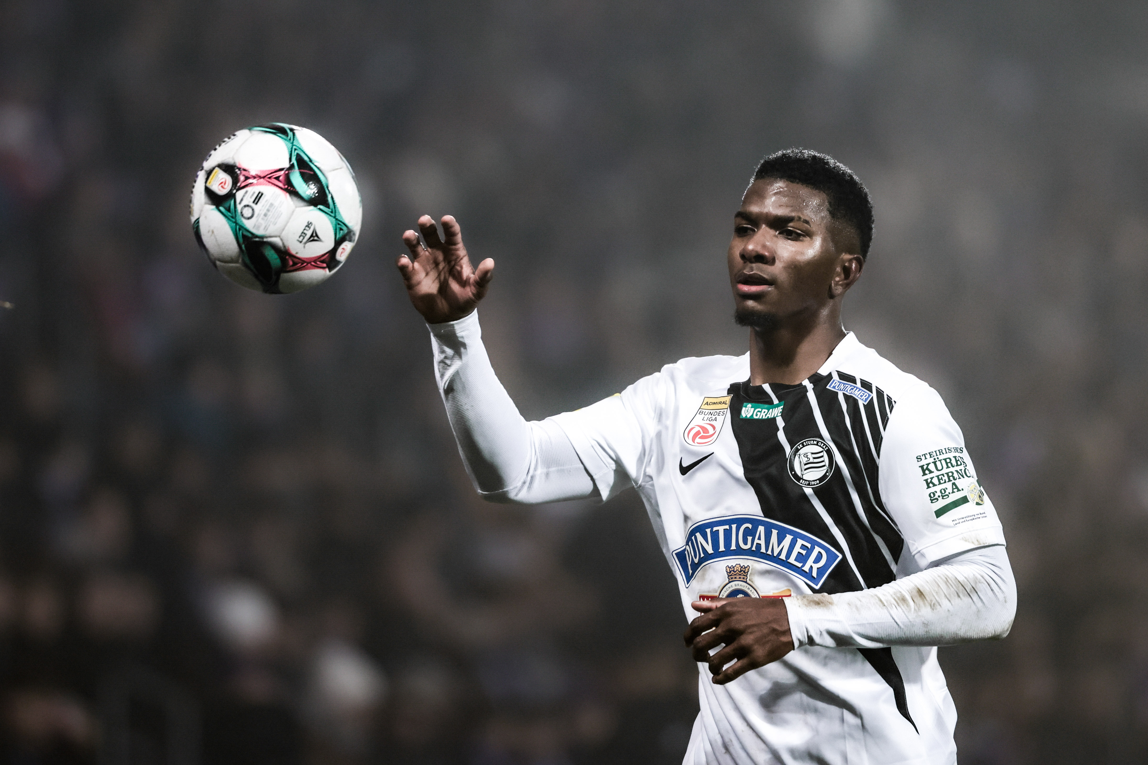 Ein Mann im weißen Trikot fängt einen weißen Ball