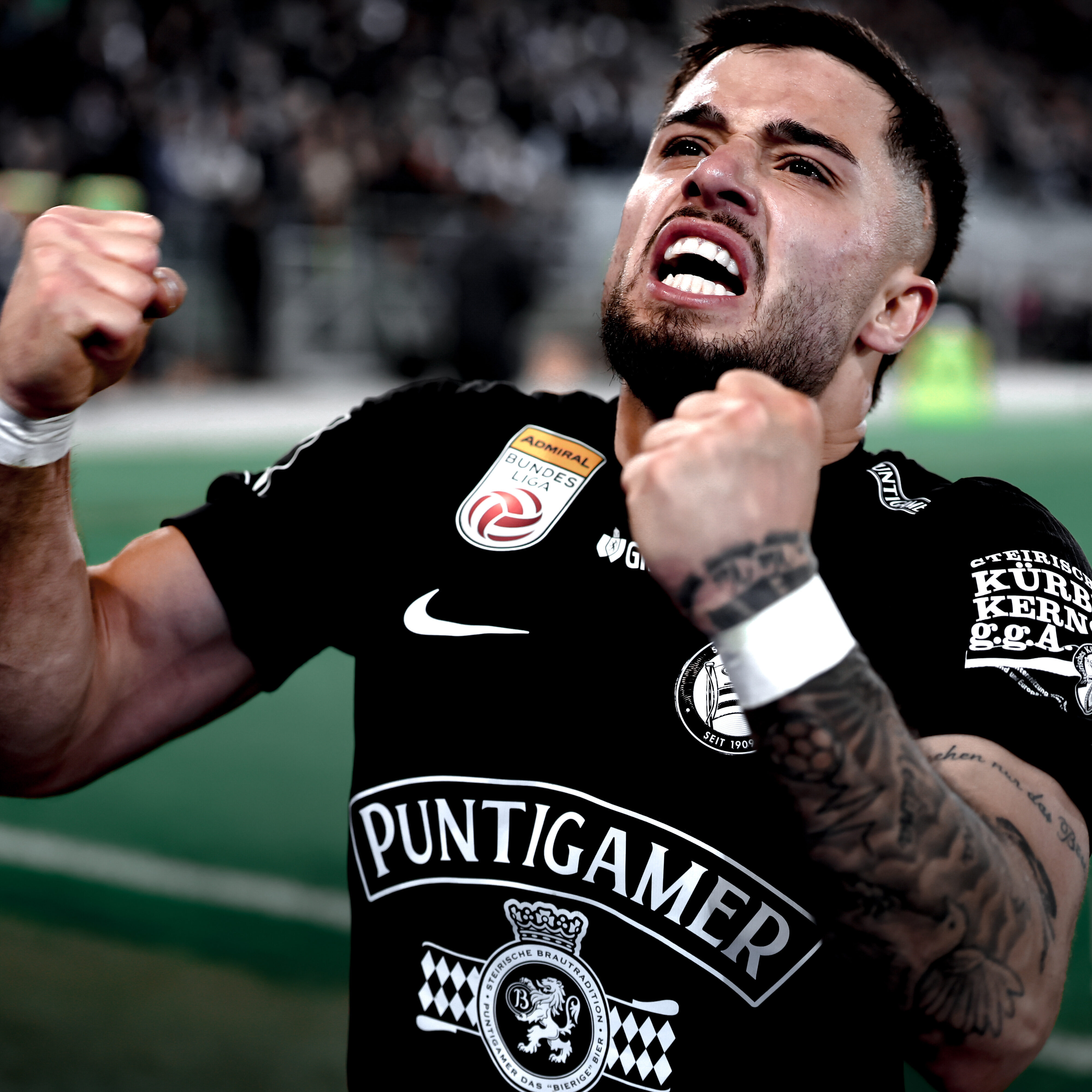 Ein Spieler im schwarzen Trikot der jubelt.