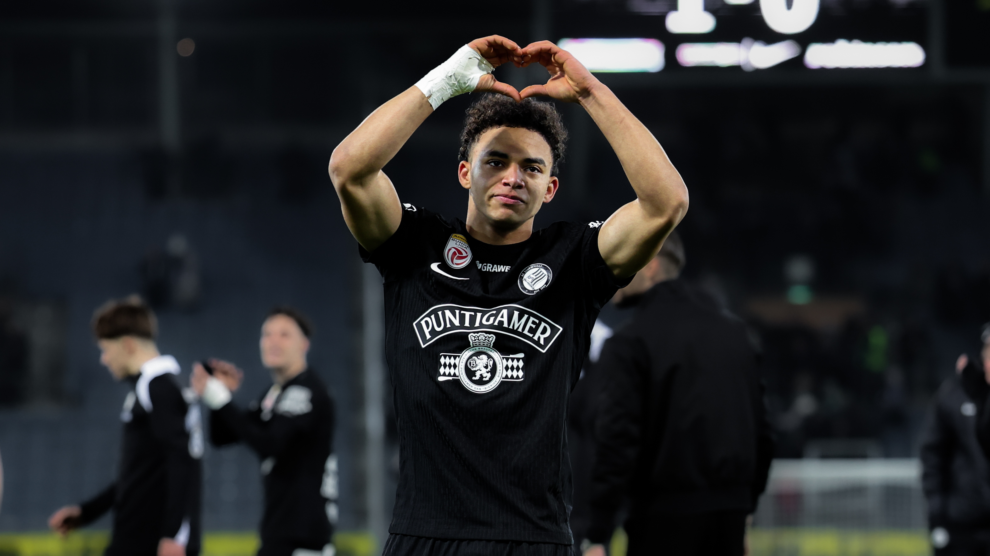 Ein Spieler in einem schwarzen Trikot zeigt ein Herz