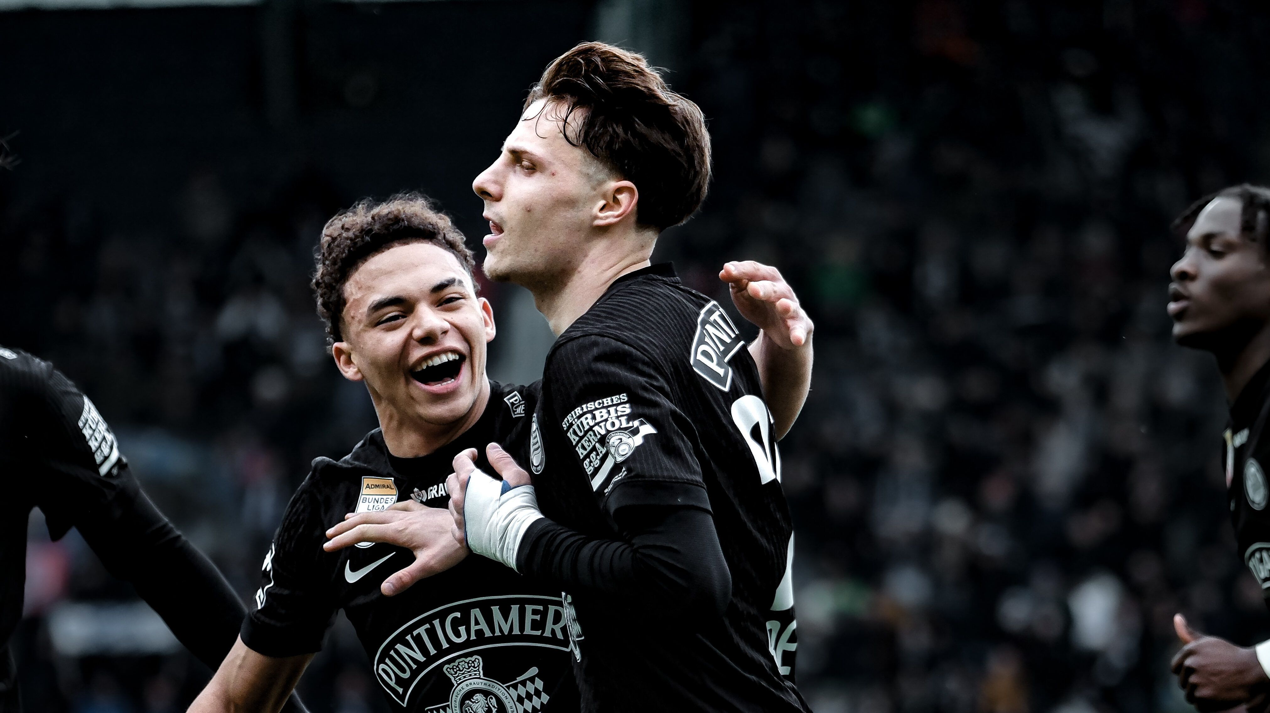 Zwei Spieler in schwarzen Trikots jubeln