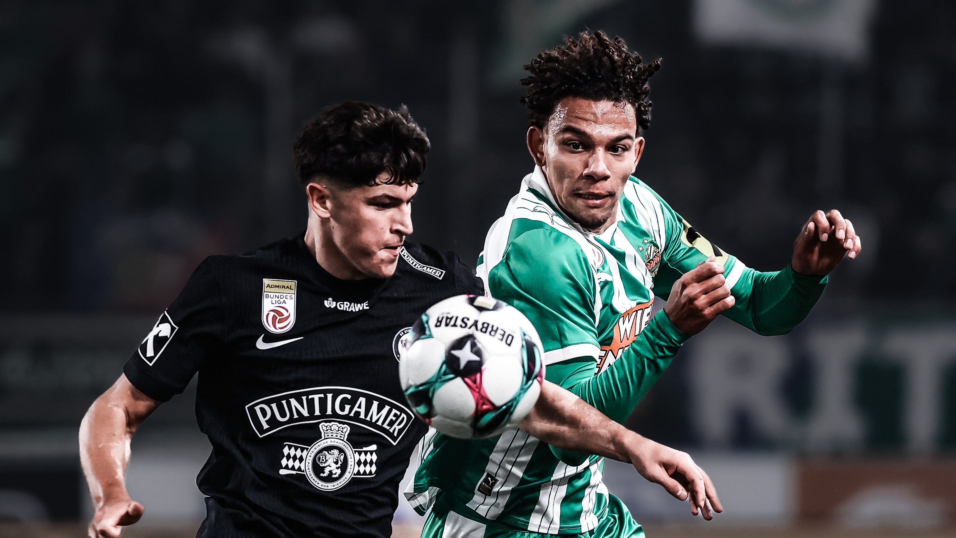 Ein Spieler in schwarz kämpft mit einem Spieler in grün-weiß um den Ball