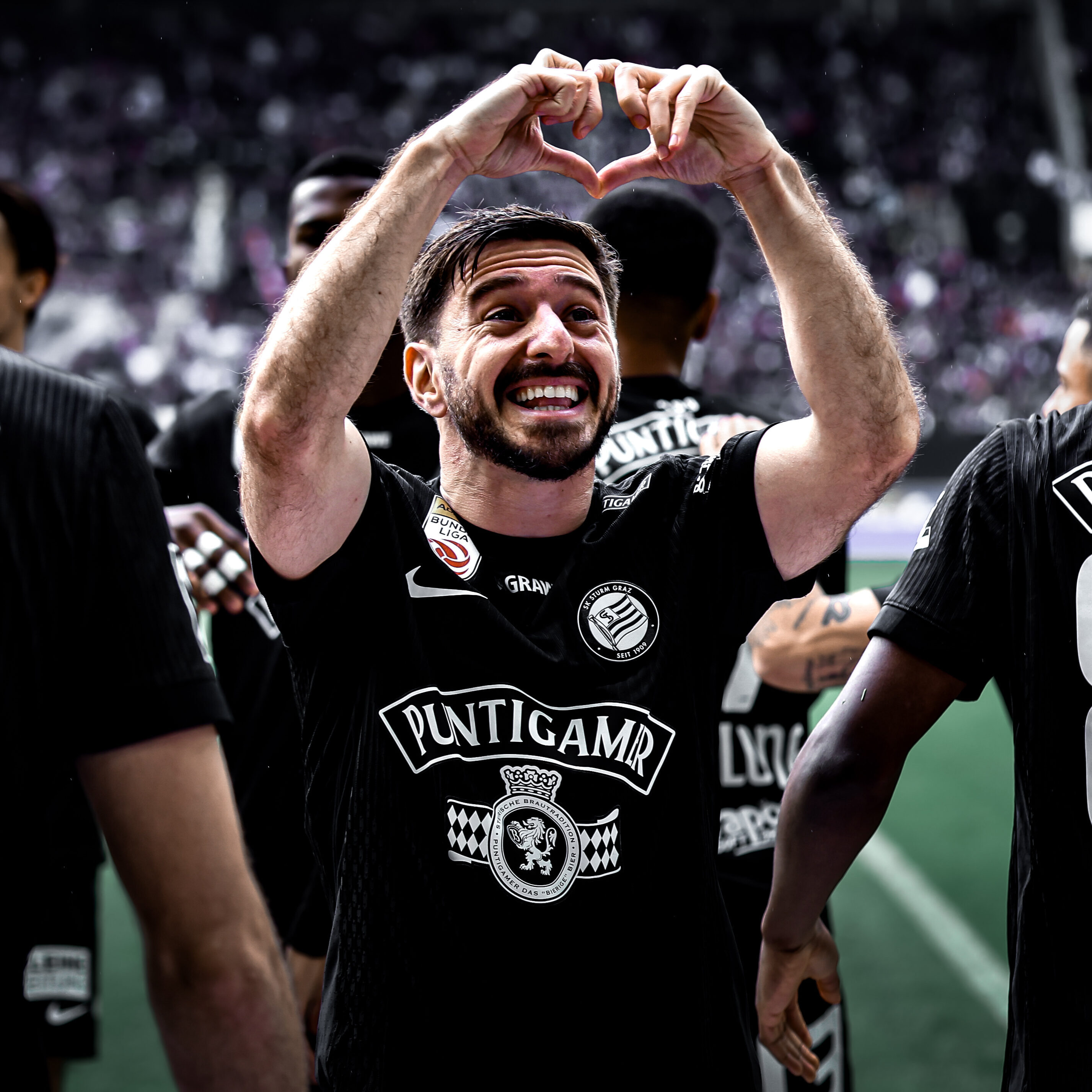 Ein Spieler in einem schwarzen Trikot formt mit den Händen ein Herz