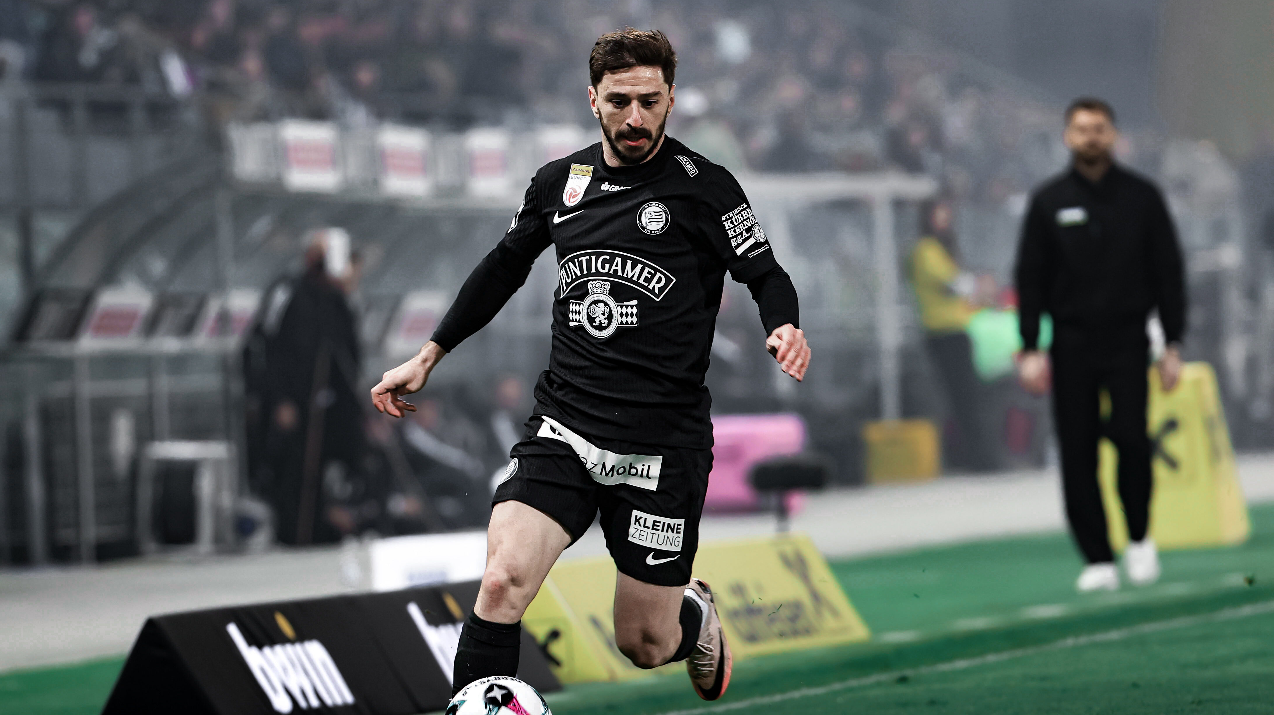 Ein Spieler in schwarz führt einen weißen Ball.