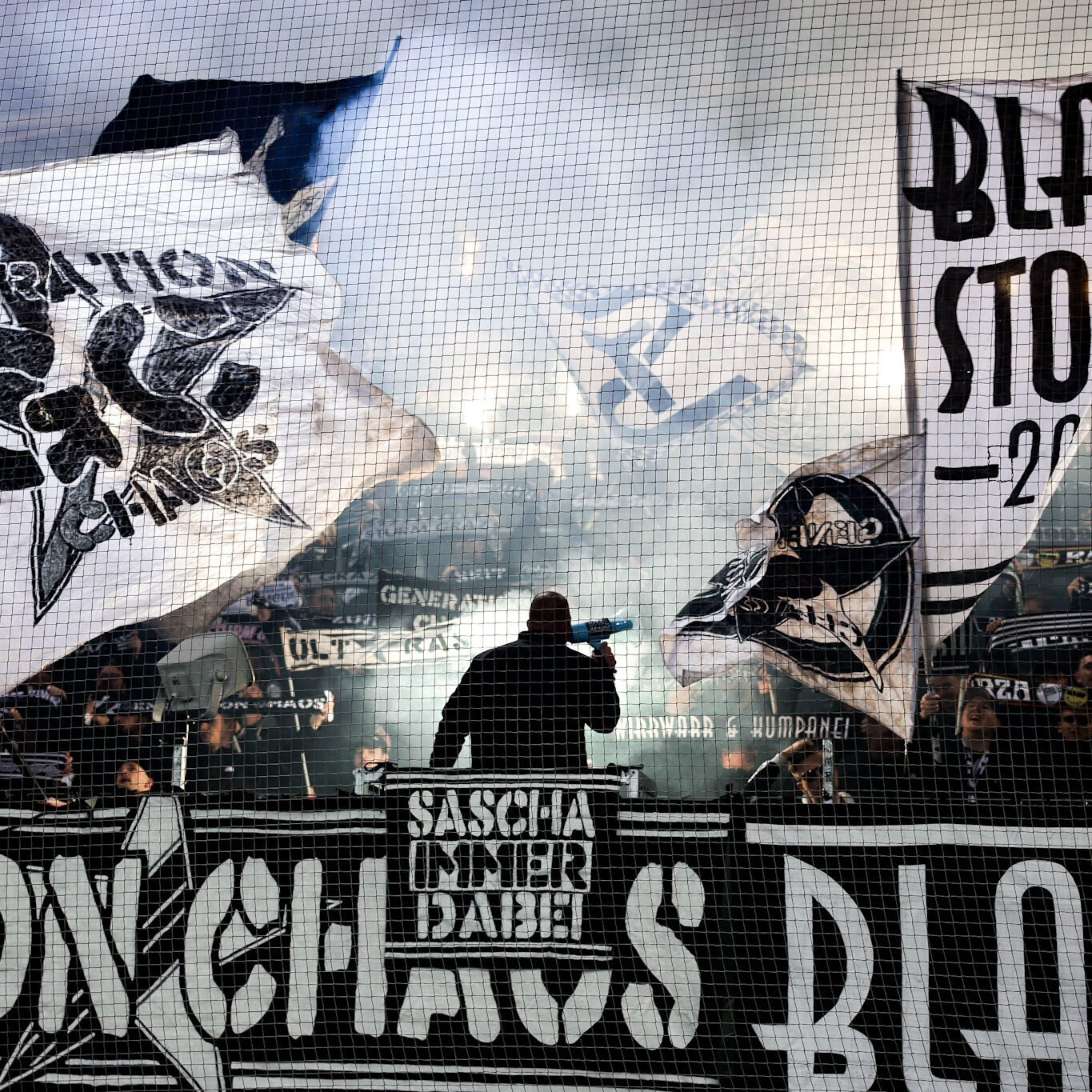 Viele Menschen halten Fahnen und Schals in die Höhe