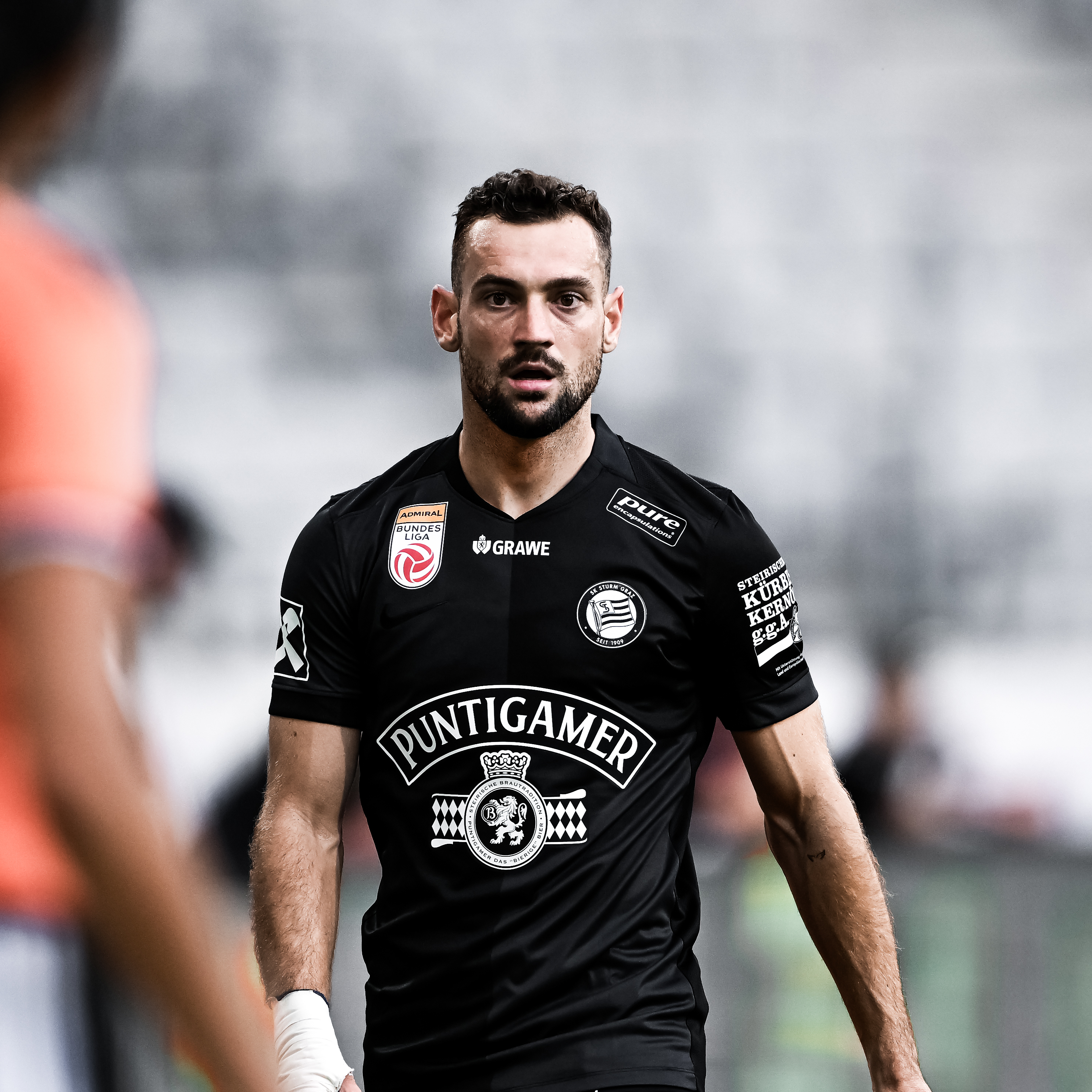 Ein Spieler in einem schwarzen Trikot schaut in die Kamera