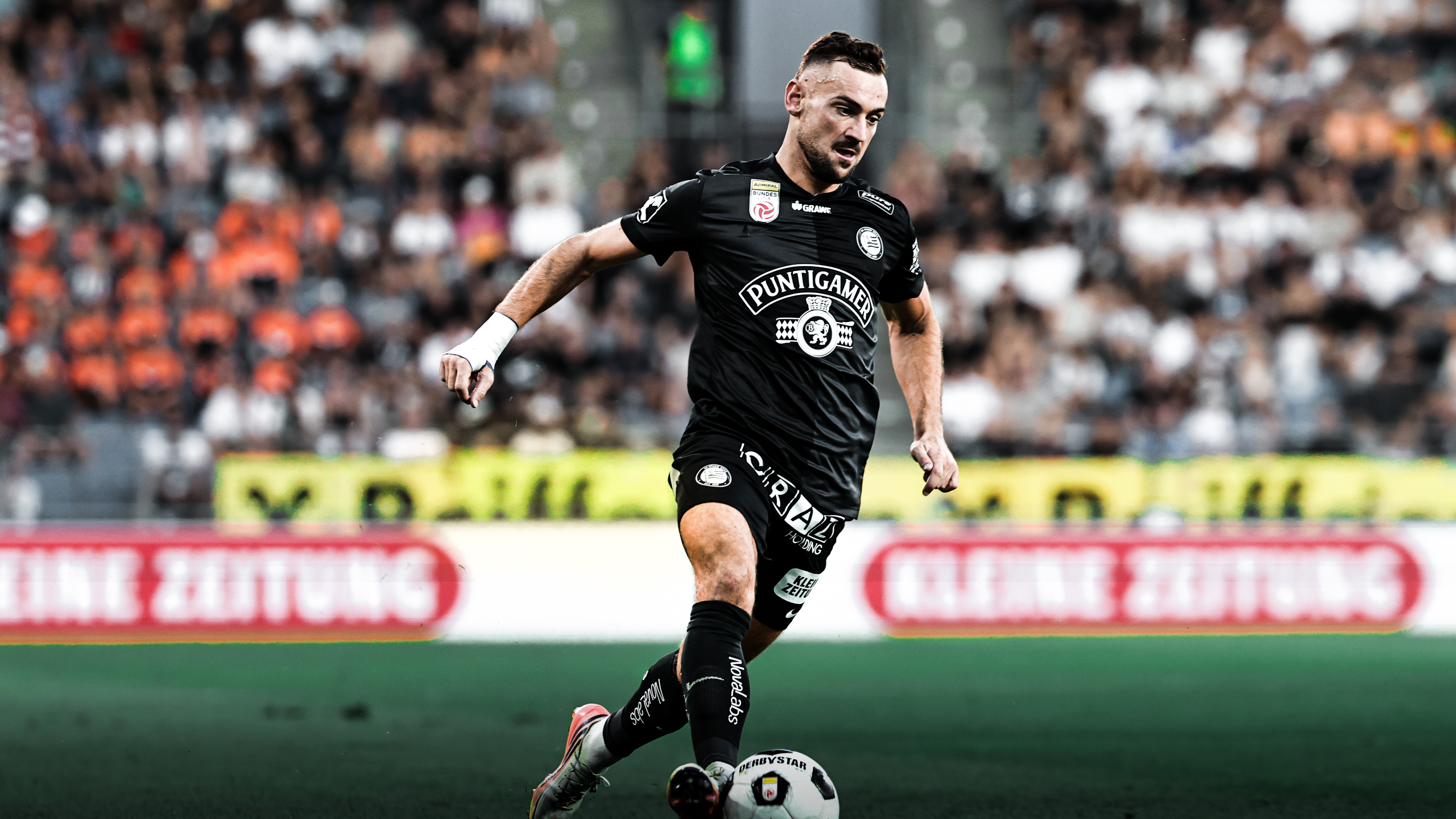 Ein Spieler in schwarz führt einen weißen Ball
