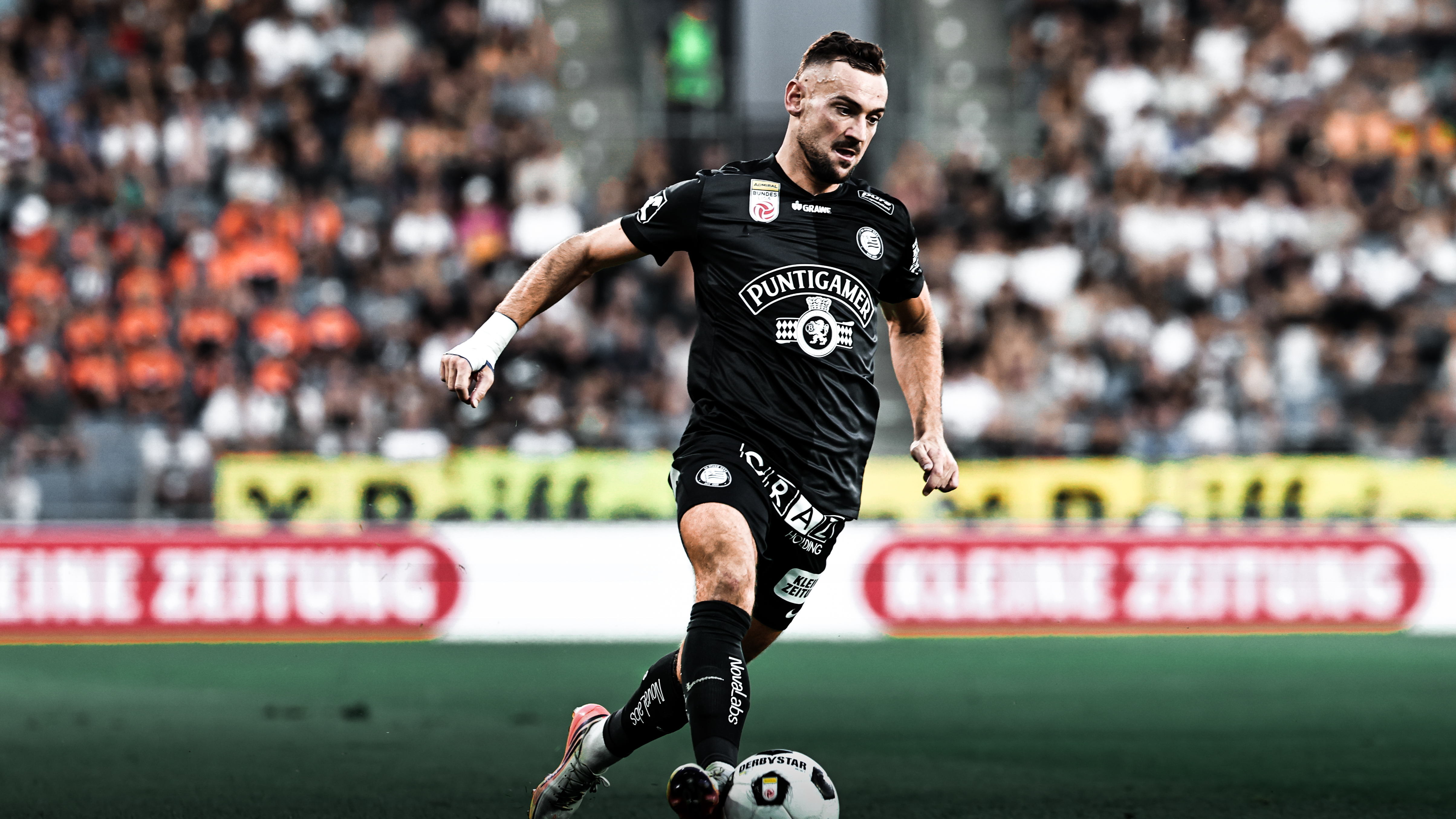 Ein Spieler in schwarz führt einen weißen Ball