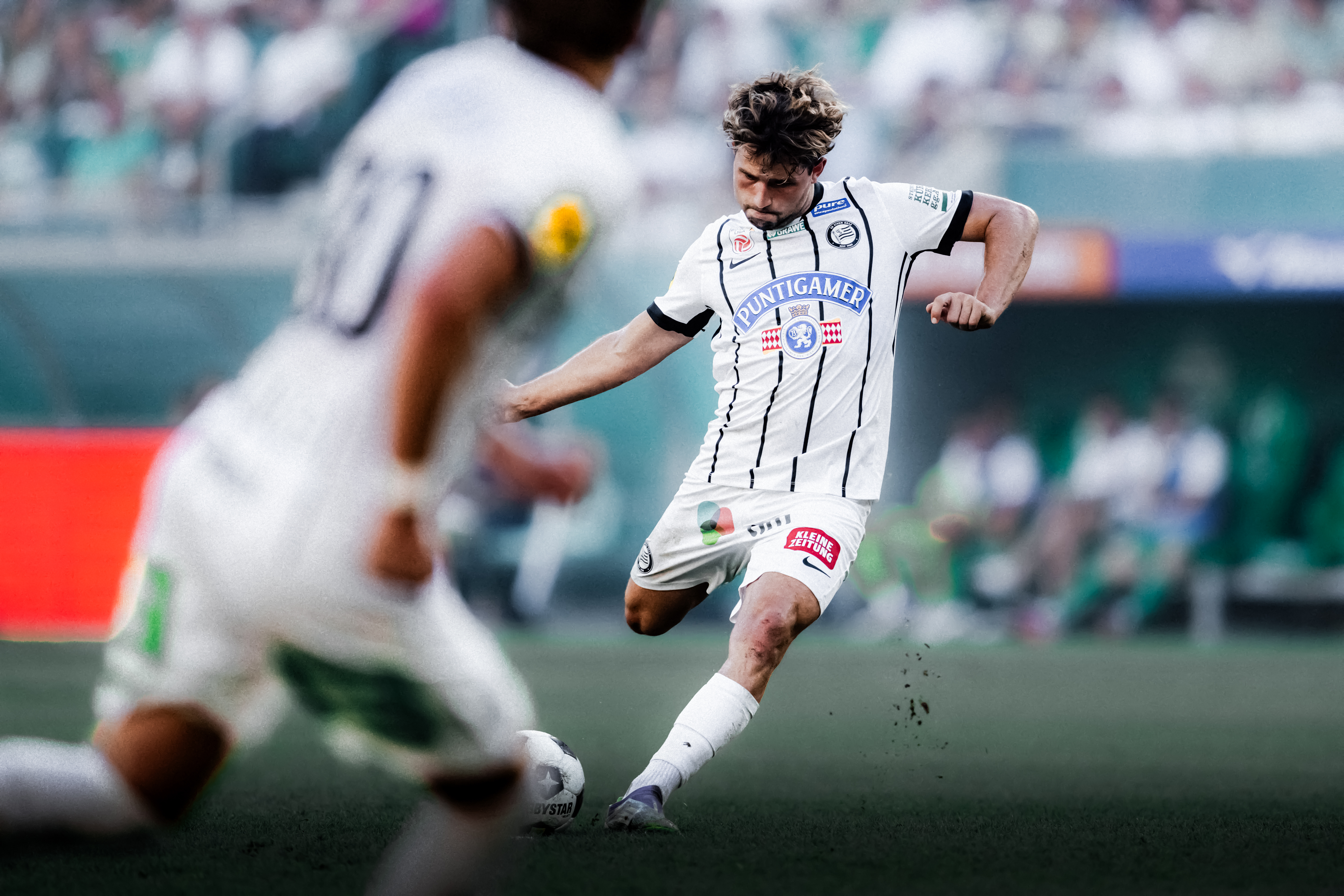 Ein Spieler in weiß schießt einen weißen Ball.