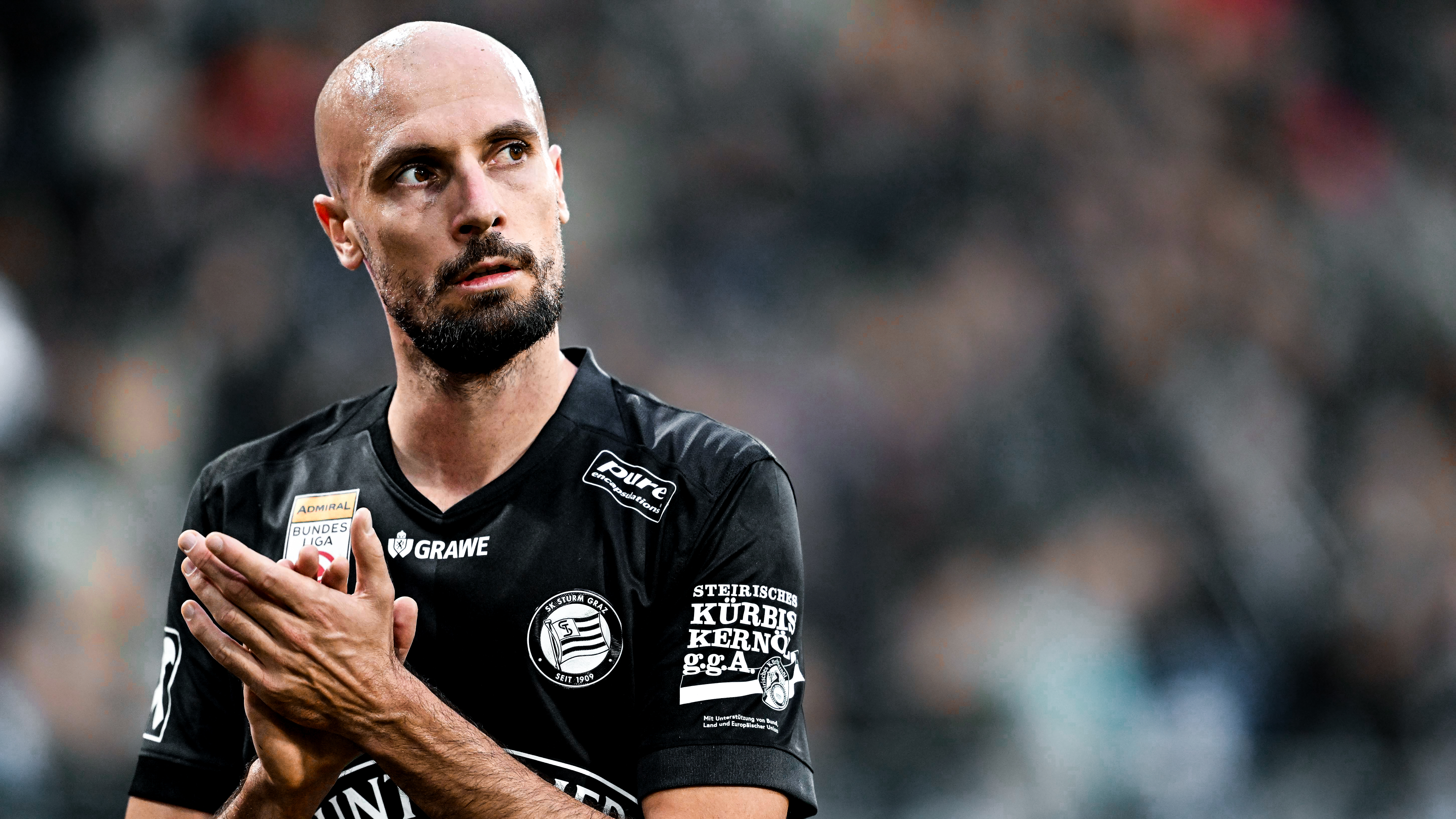 Ein Spieler in einem schwarzen Trikot klatscht.,