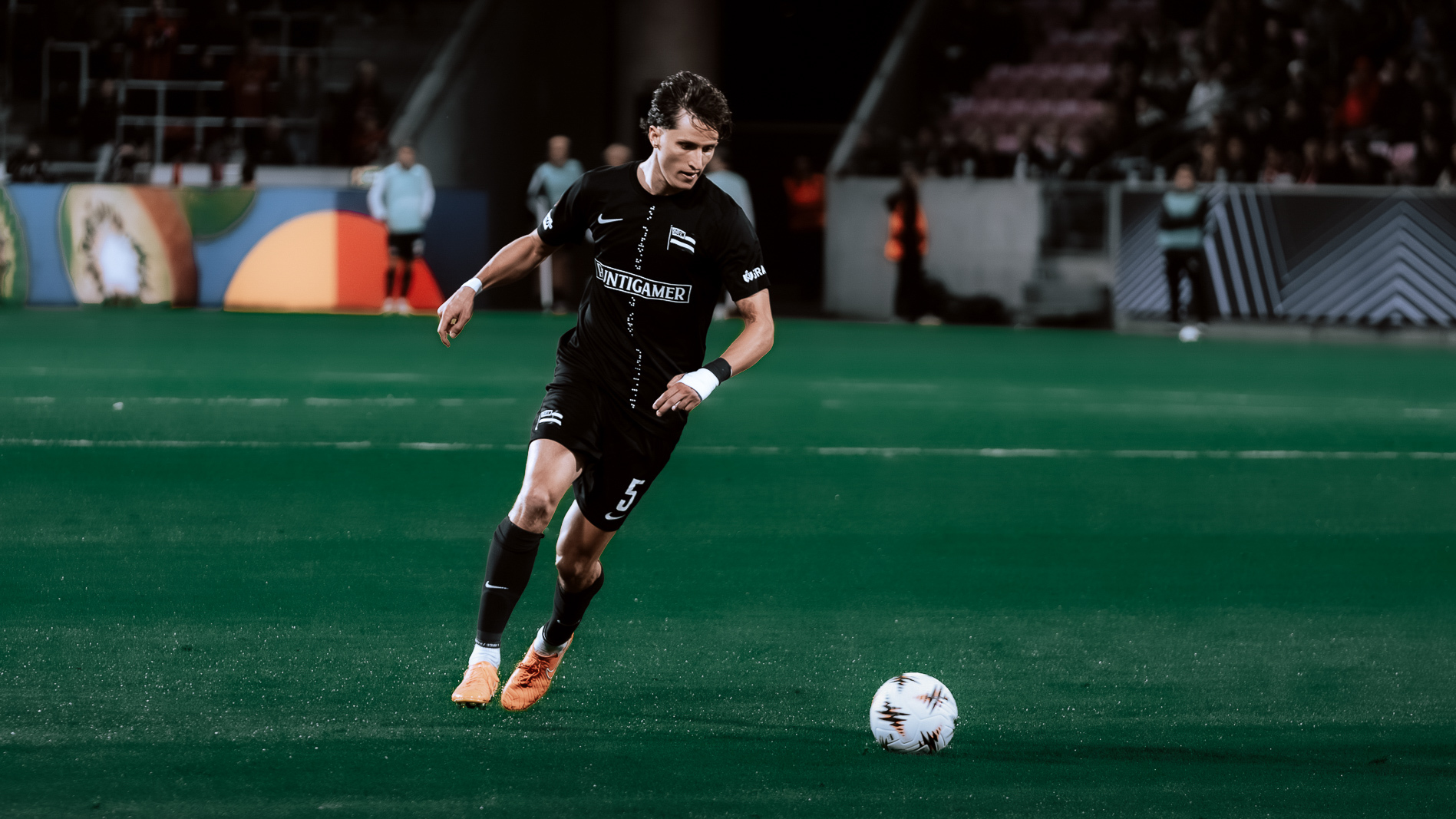 Ein Mann mit Ball in einem schwarzen Trikot