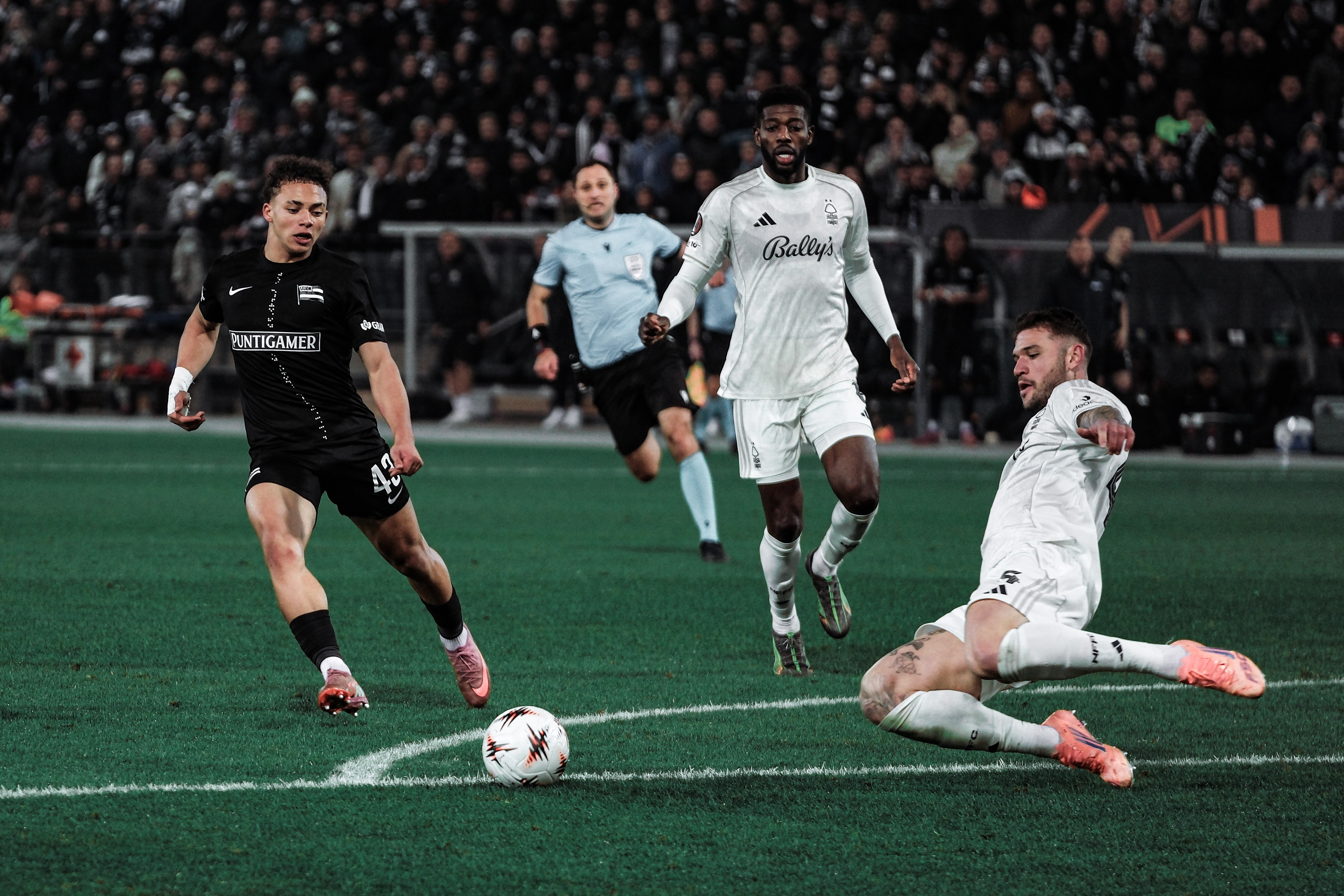 Ein Spieler grätscht nach einem Ball