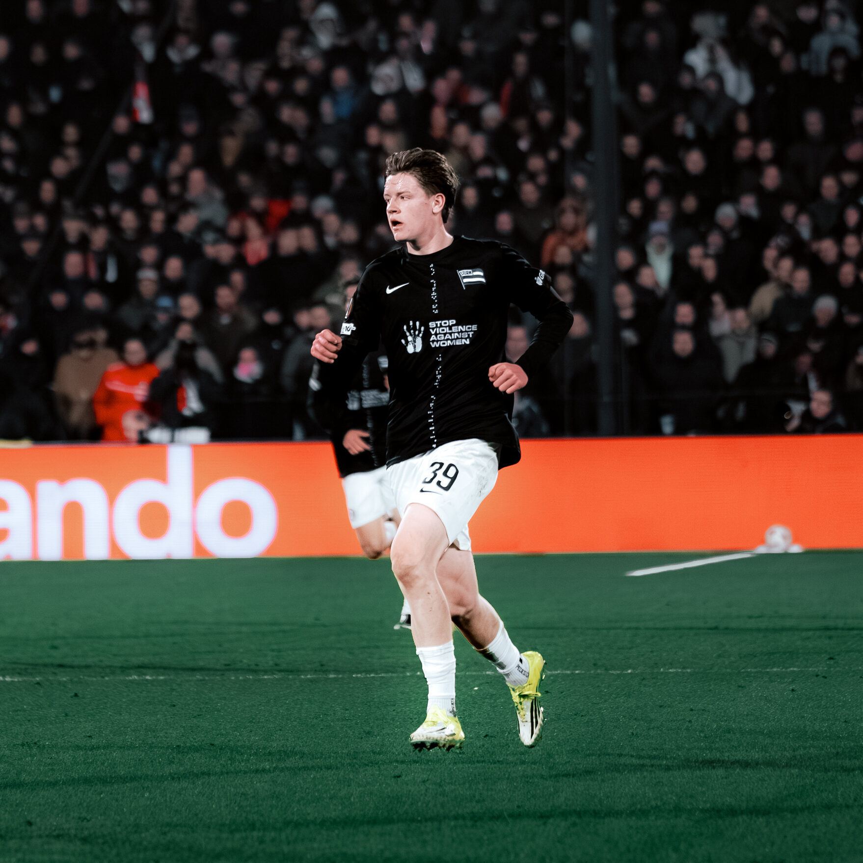 Ein Spieler in schwarz und weiß läuft über den Rasen.