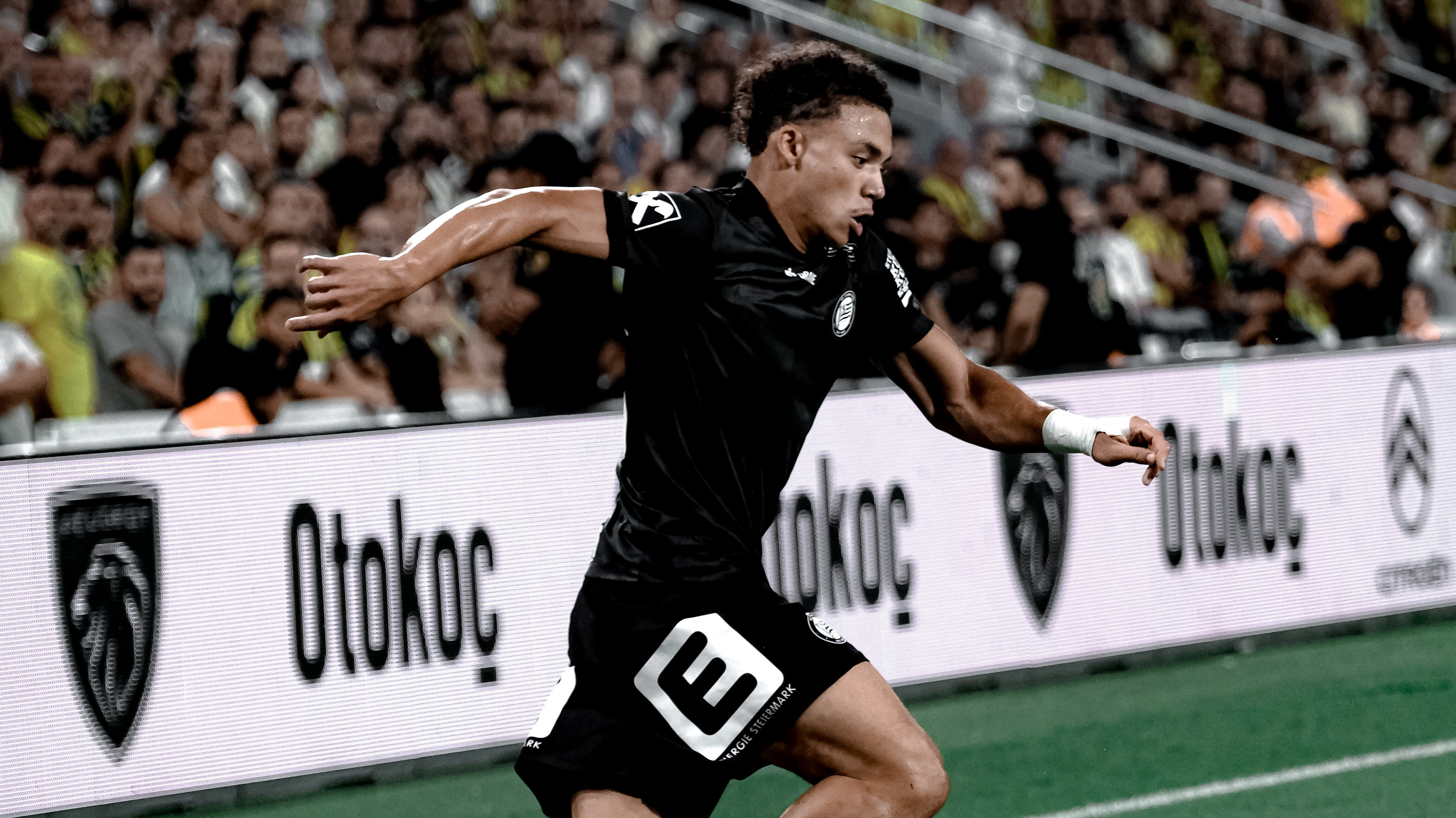 Ein Spieler in schwarz führt einen weißen Ball am Fuß