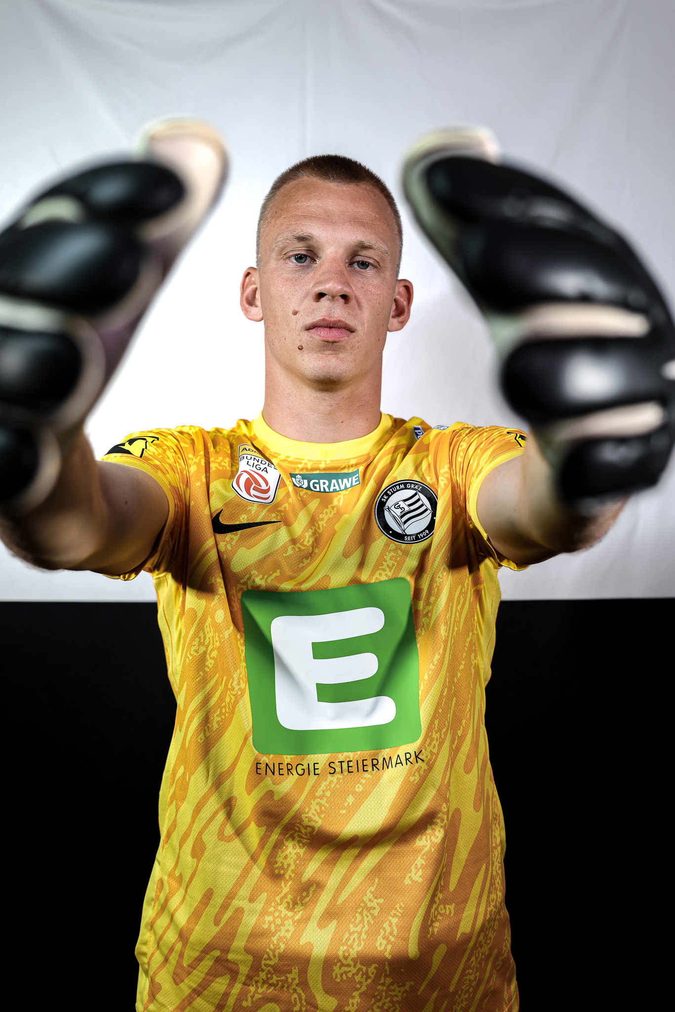 Mann mit gelbem Shirt und Handschuhen
