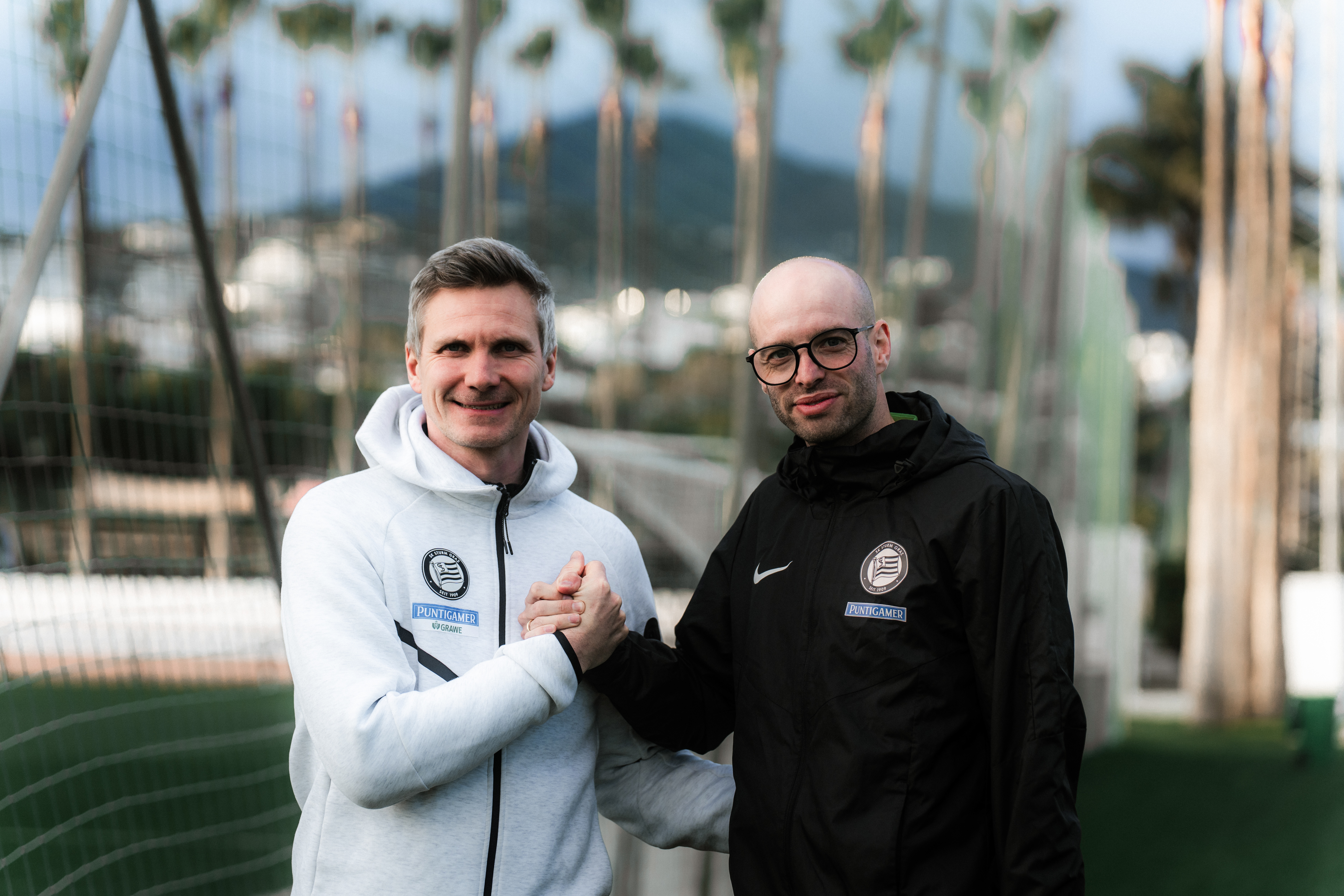 Zwei Männer klatschen in Marbella ein.