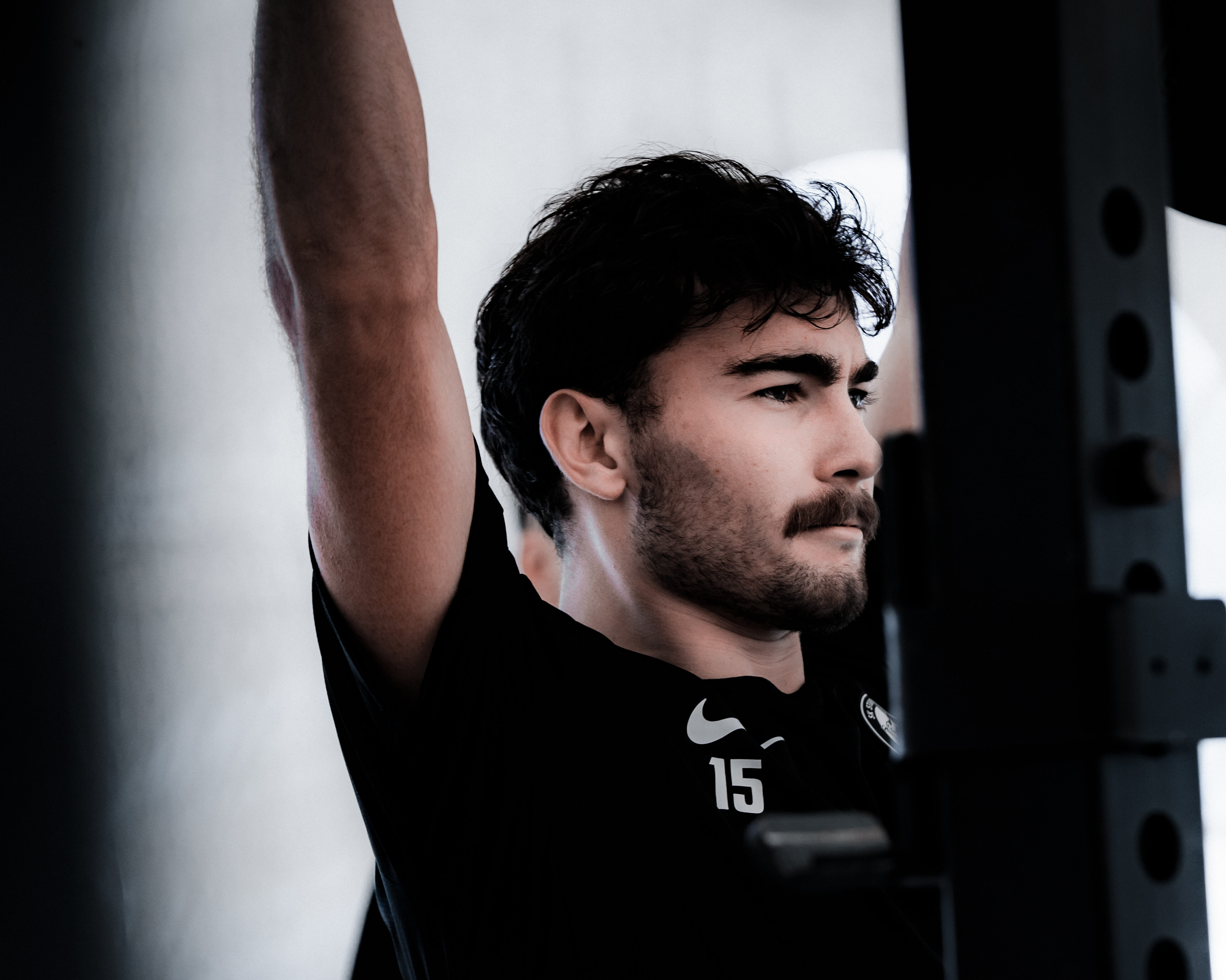 Ein Mann, der eine Hantel über den Kopf drückt.