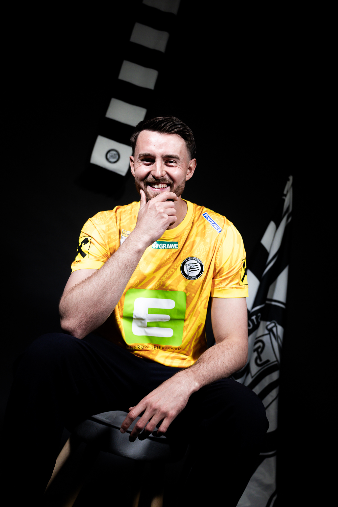 Mann in gelbem Fußballtrikot fasst sich ans Kinn.