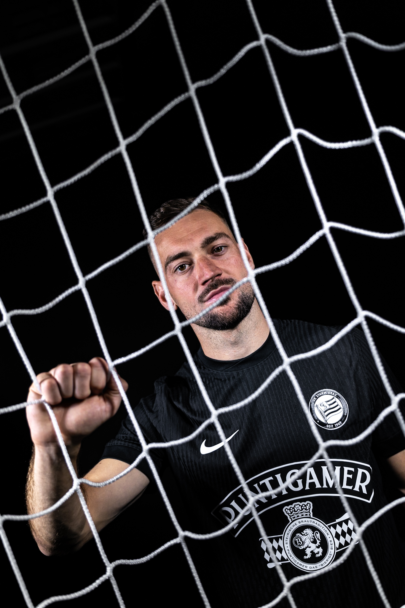 Mann in Trikot steht hinter Tornetz.