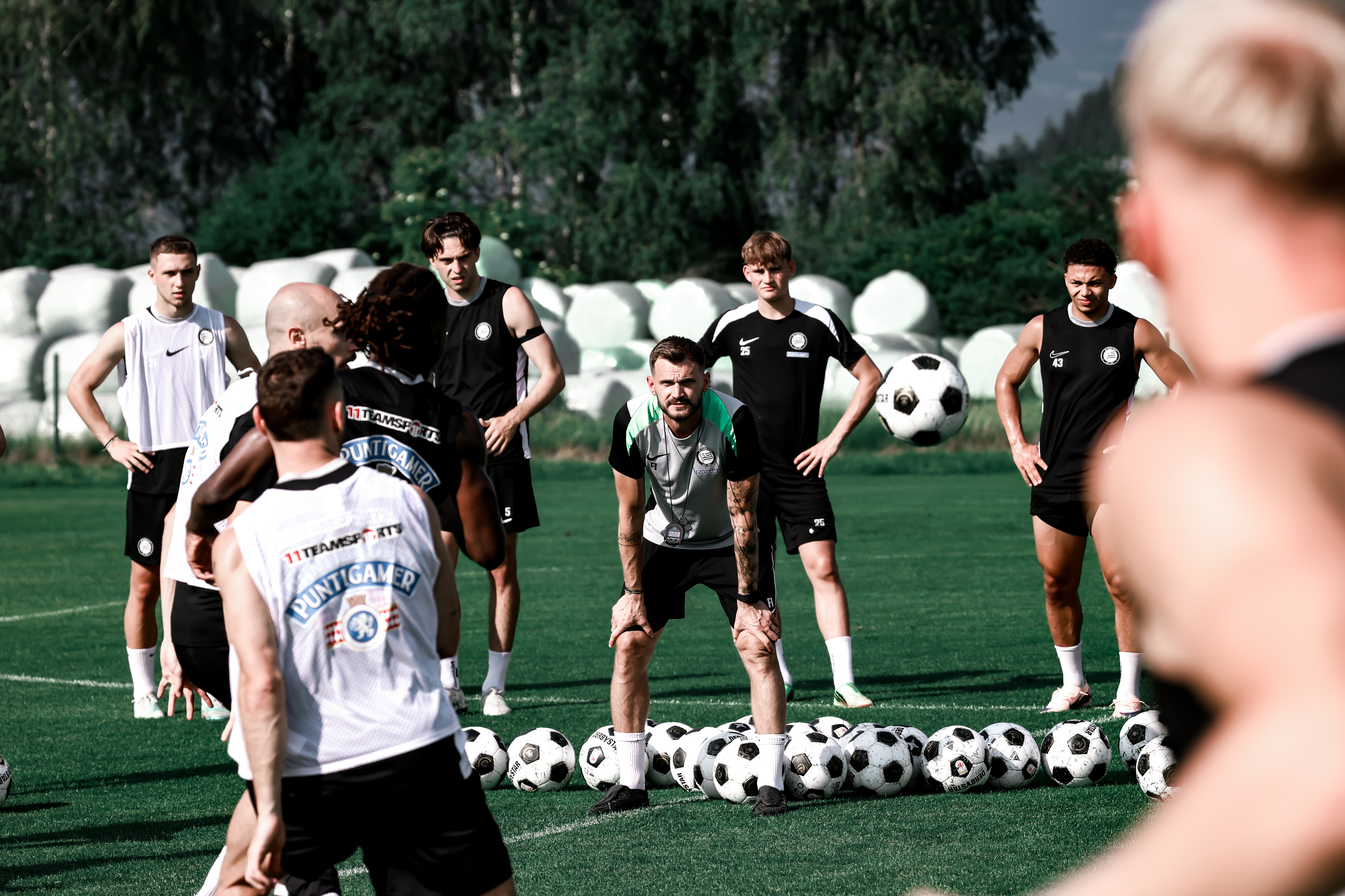Fußballer stehen am Trainingsplatz und beginnen eine Übung.