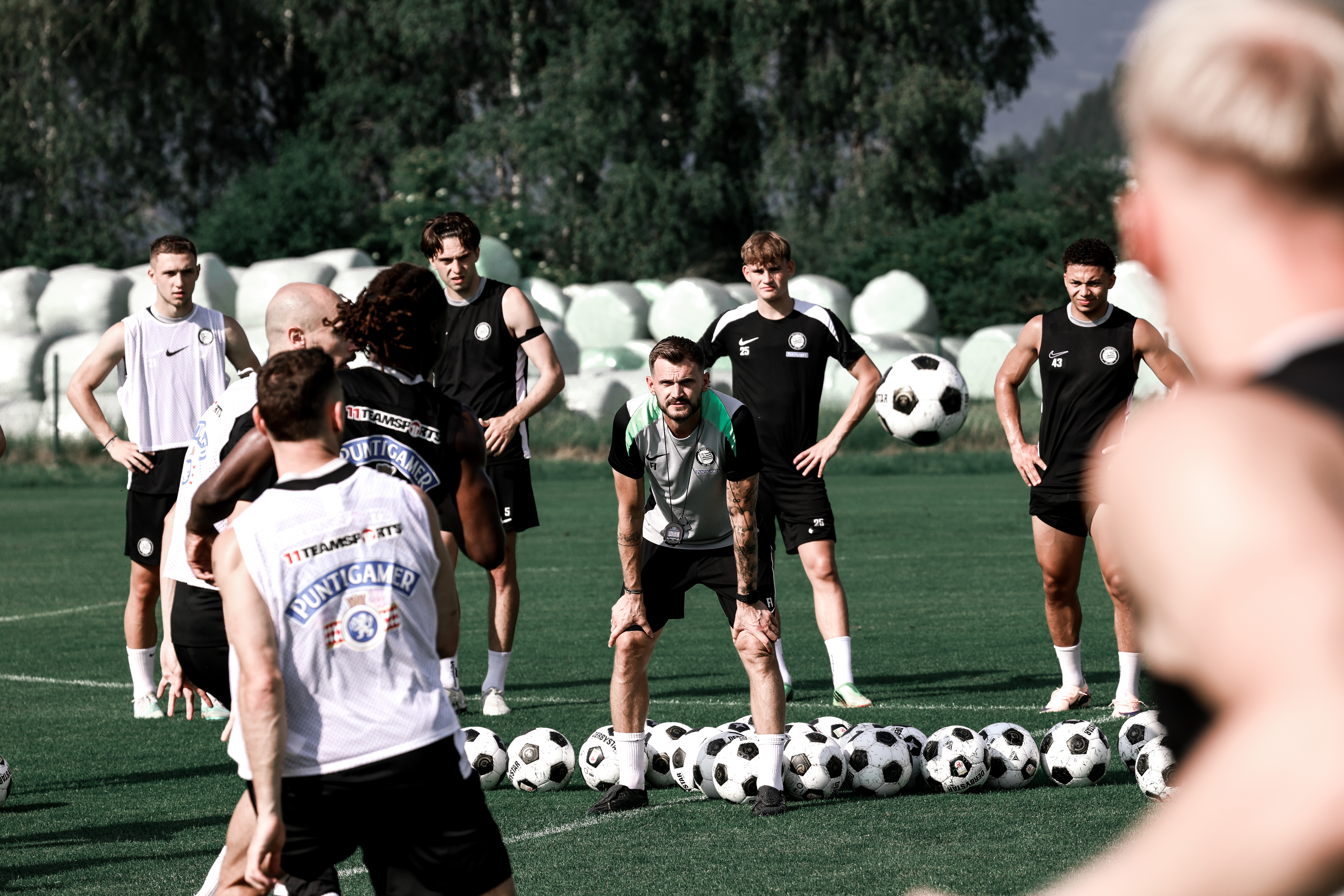 Fußballer stehen am Trainingsplatz und beginnen eine Übung.