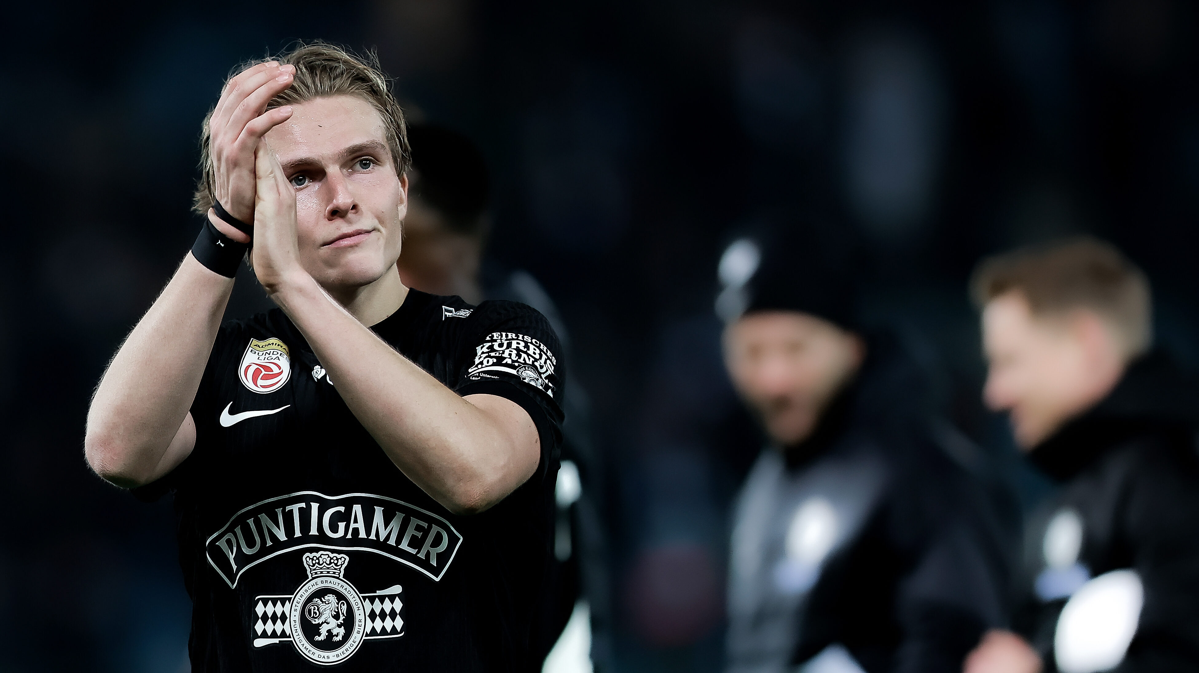 Ein Mann im schwarzen Trikot klatscht in die Hände.