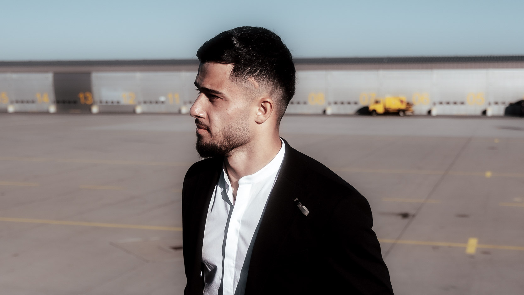 Ein Mann in einem schwarzen Anzug schaut in die Ferne