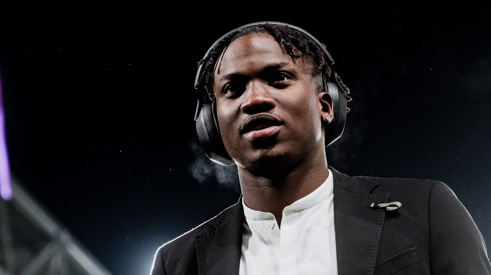 Ein Mann in Anzug und weißem Hemd schaut in die Ferne.