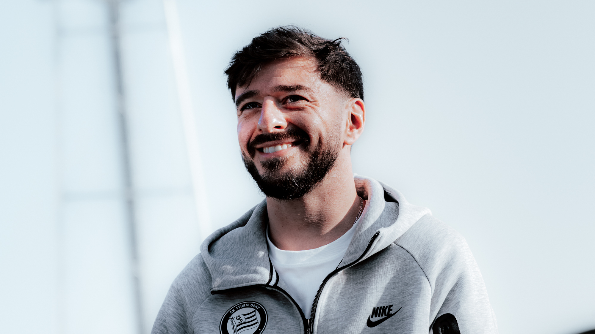 Ein Spieler in einer grauen Weste lacht