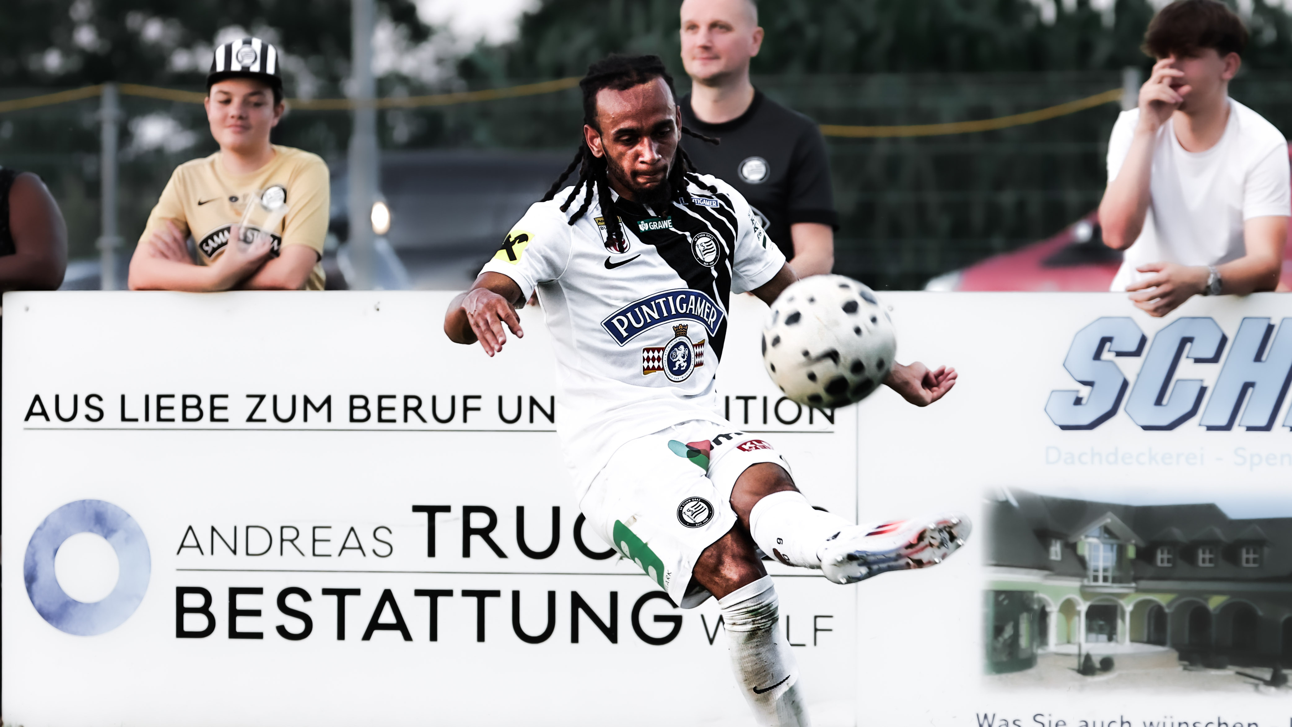 Ein Spieler in weiß schießt einen weißen Ball