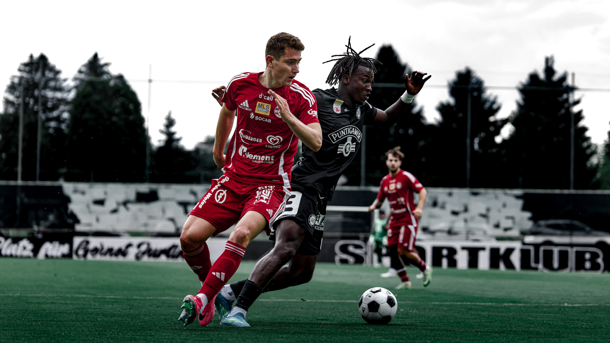 Zwei Personen kämpfen um den Ball am Fußballfeld