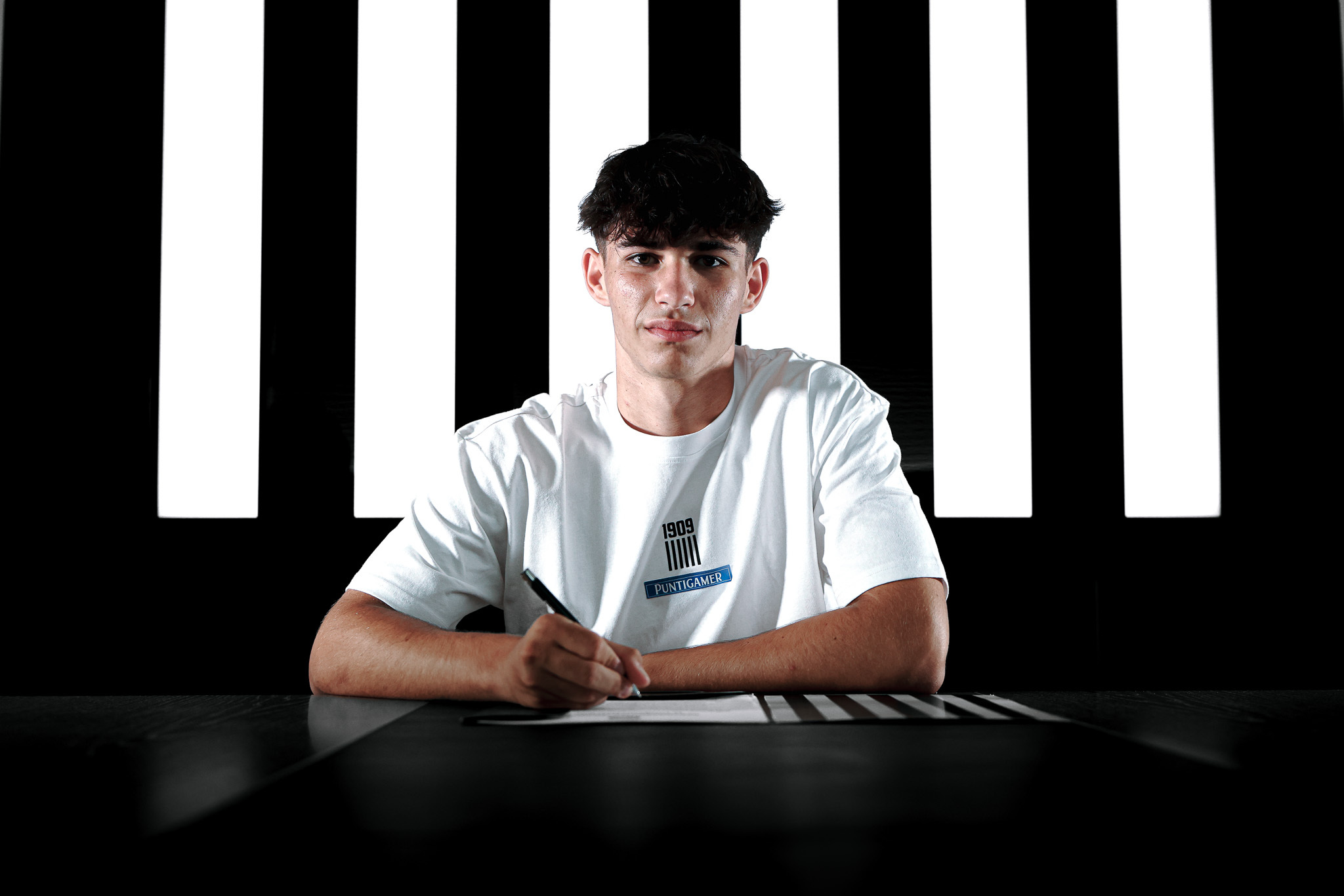 Ein Mann im weißen Shirt unterschreibt einen Vertrag