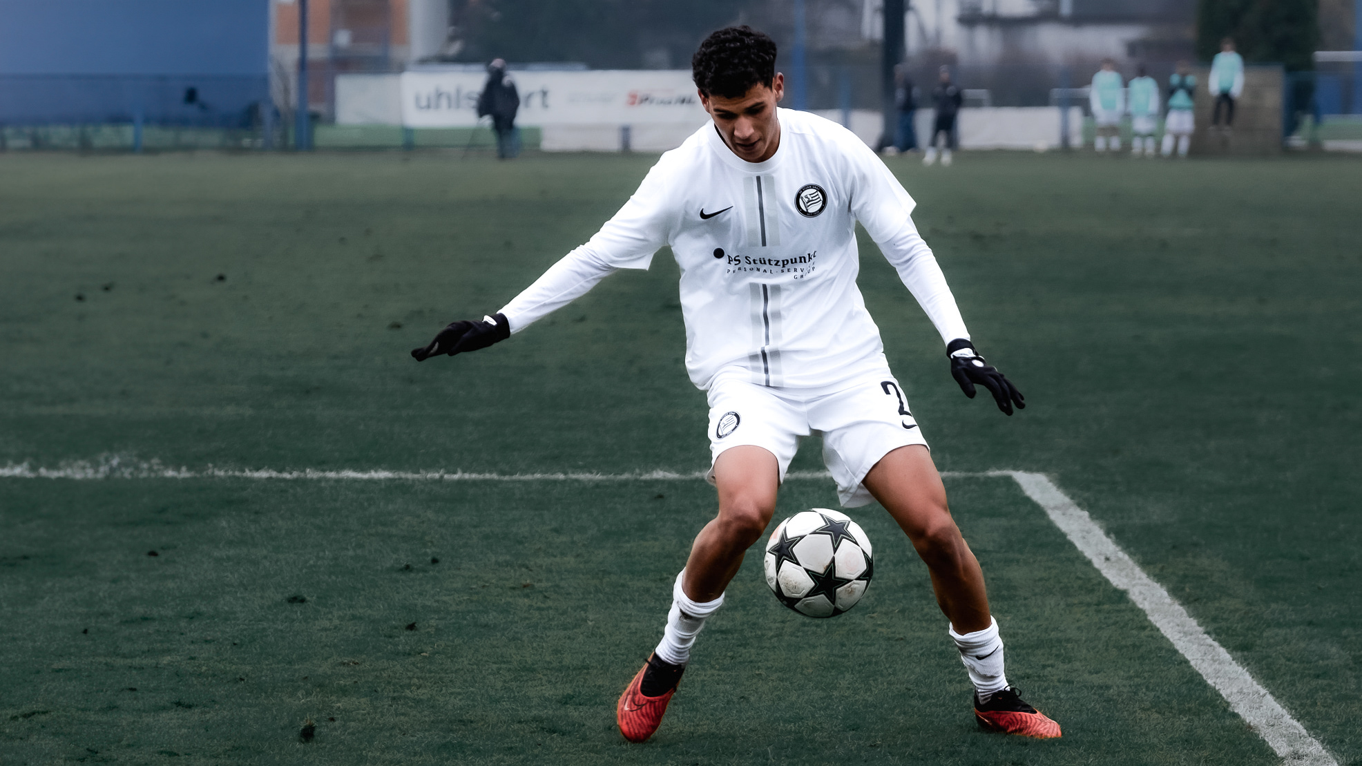 Ein Spieler mit Ball in einem weißen Trikot