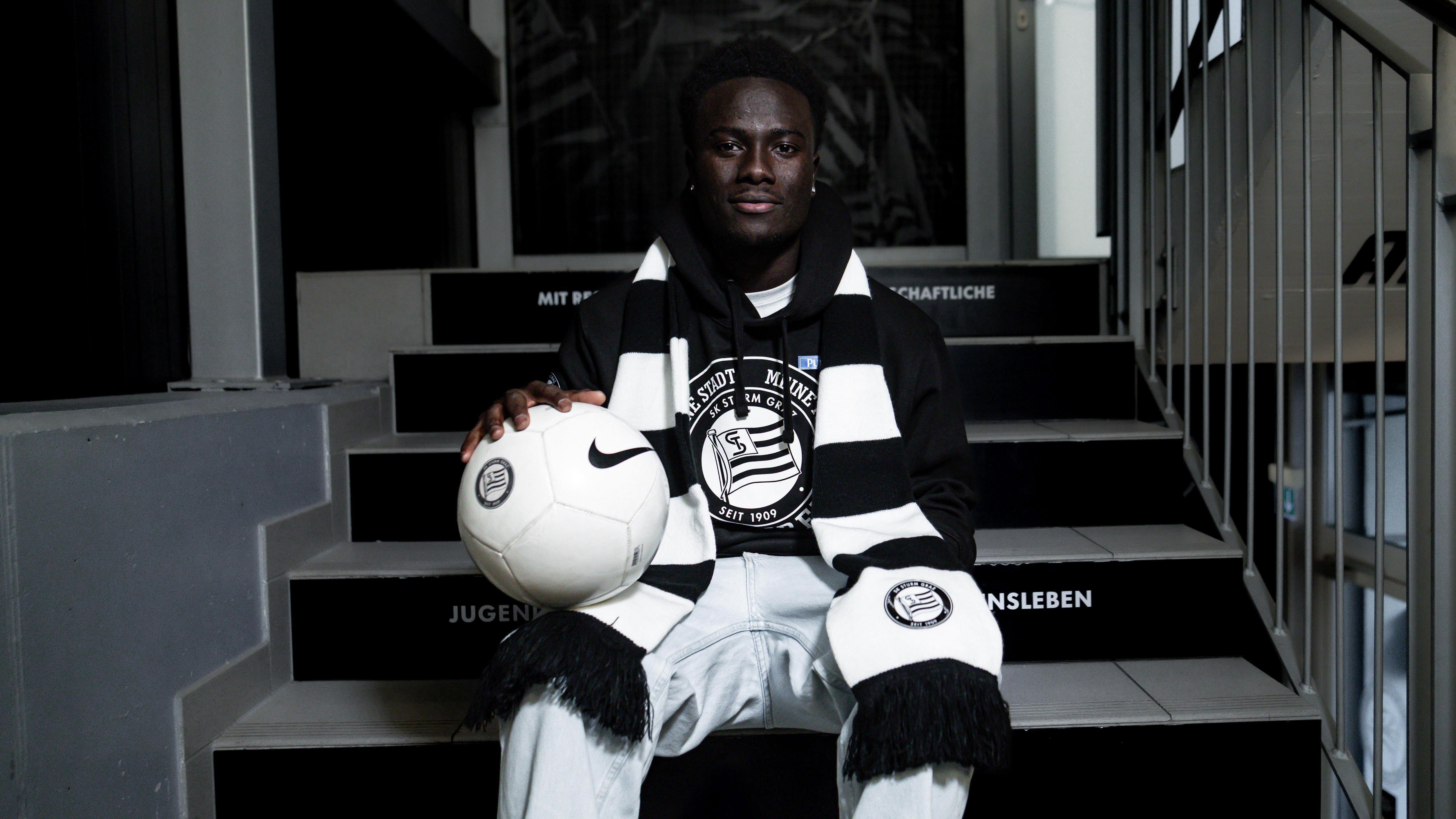 Ein Spieler sitzt mit einem BAll und einem Schal auf einer Stiege