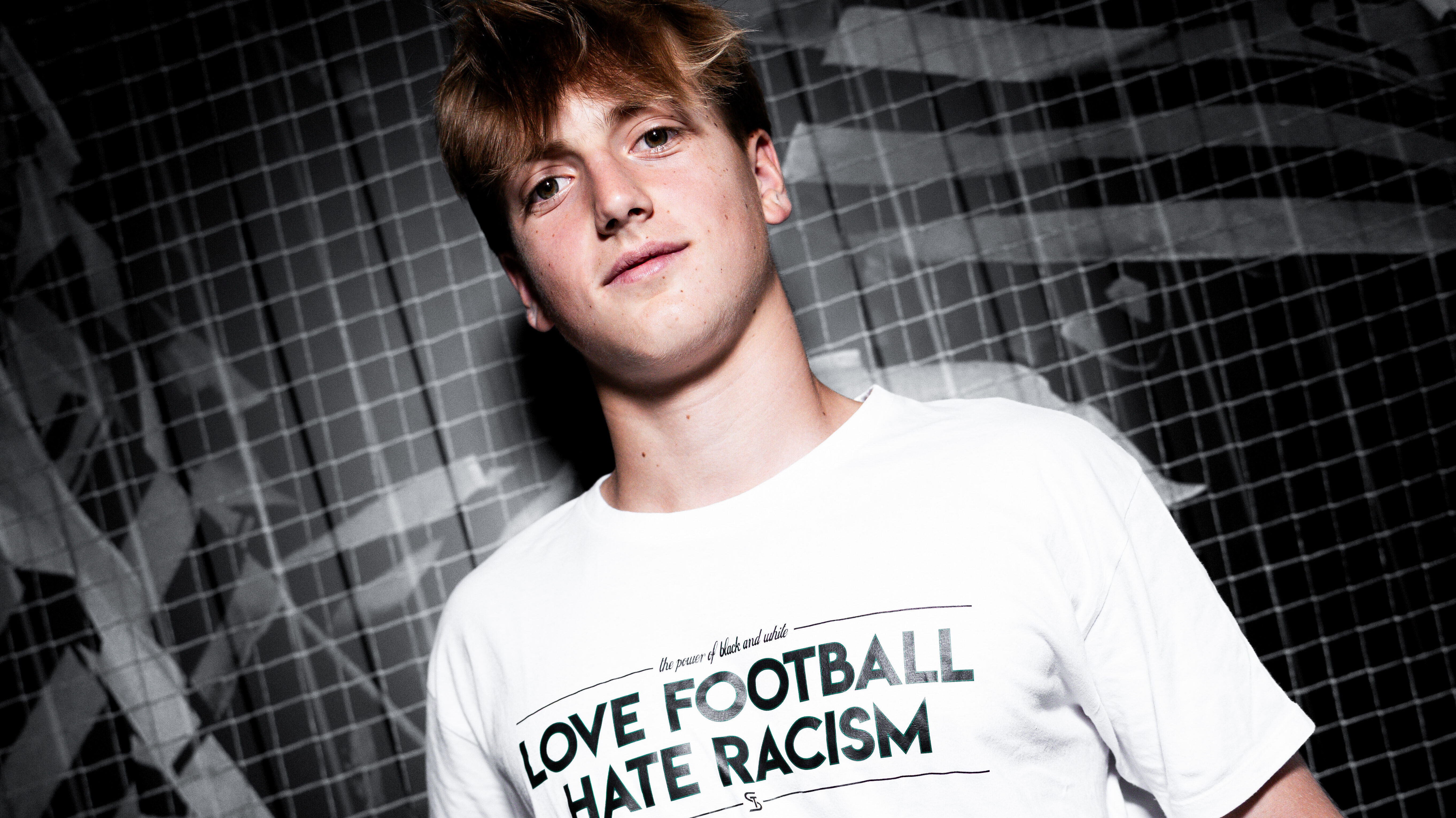 Ein Spieler in einem weißen Shirt hält einen Ball und schaut in die Kamera.