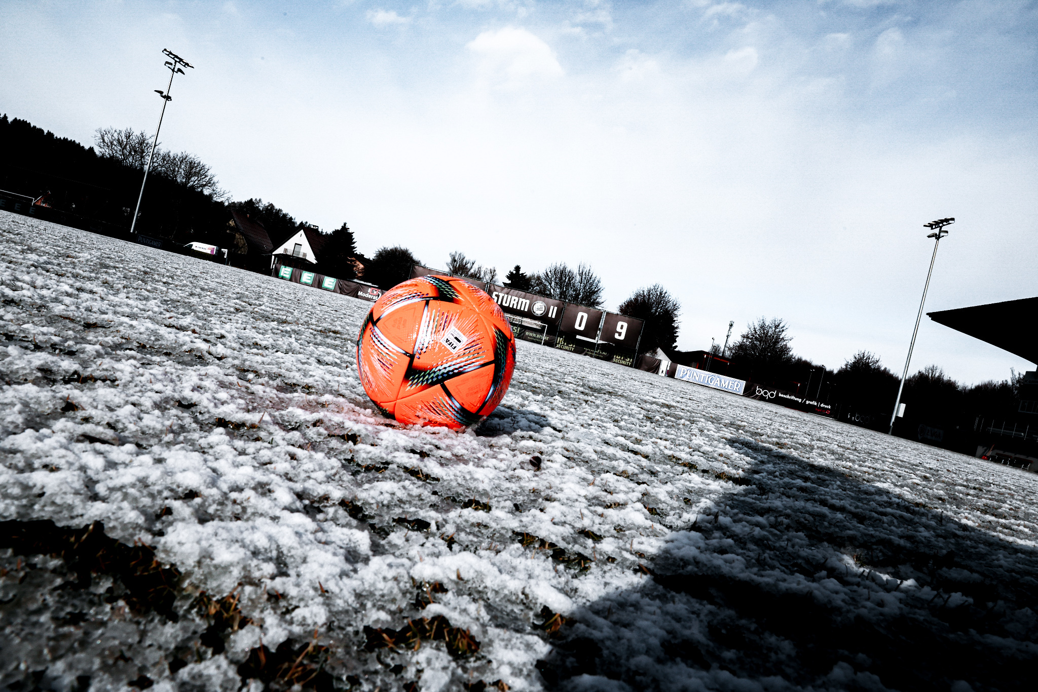 Oranger Ball liegt auf Feld im Schnee