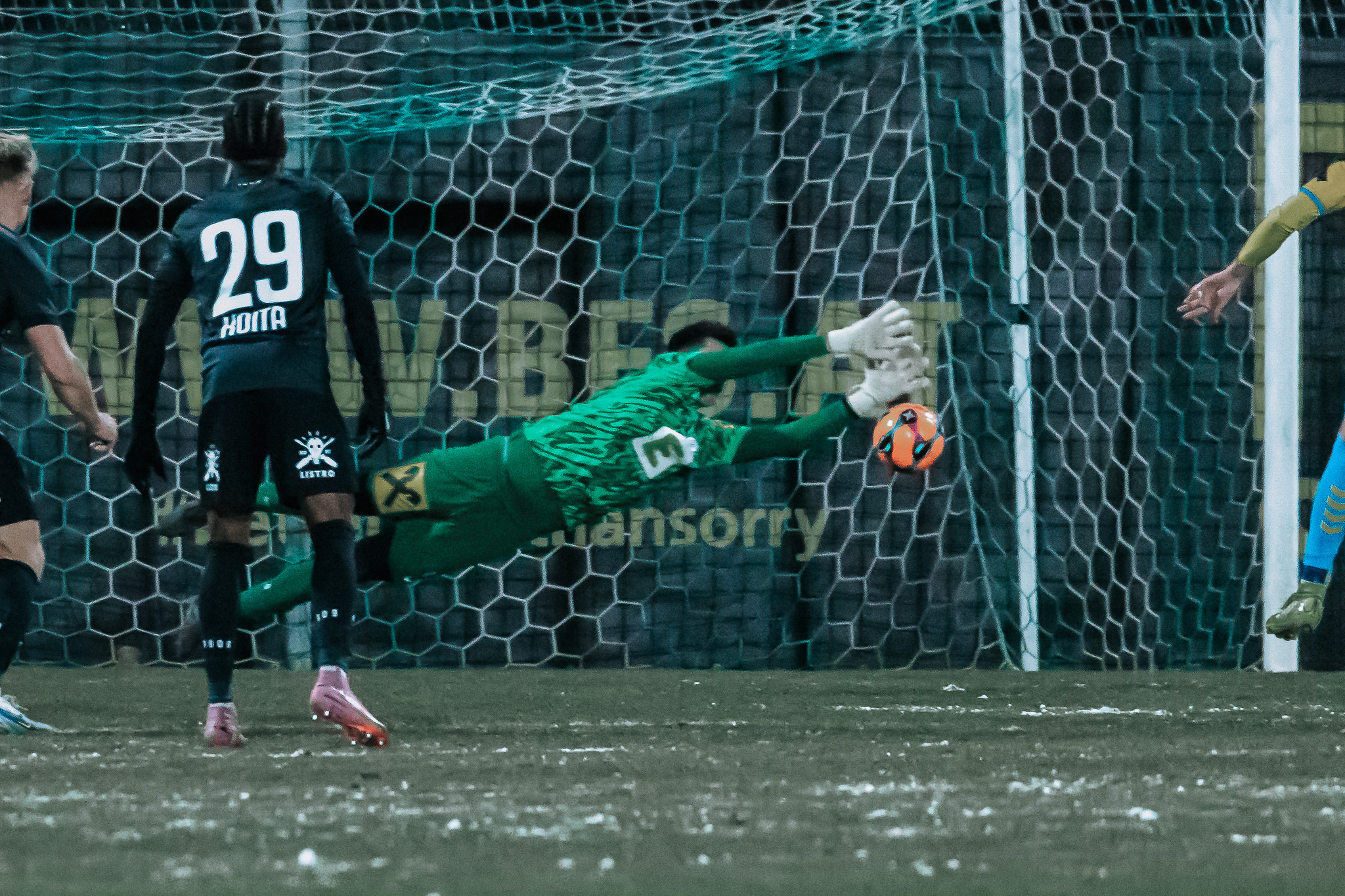 Zwei Fußballer, ein Spieler, ein Tormann in Aktion.