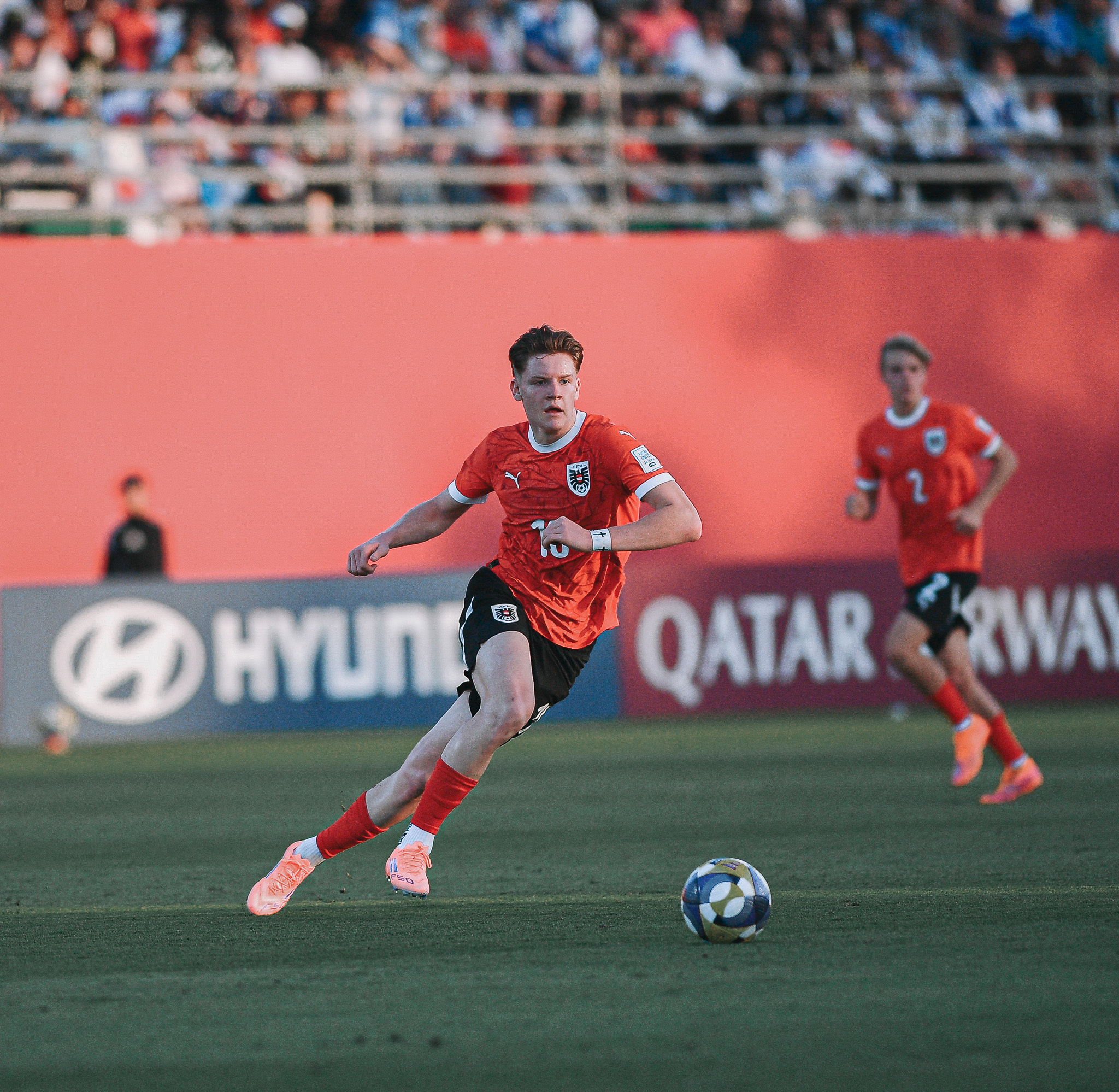 En Mann im roten Dress spielt einen Ball.