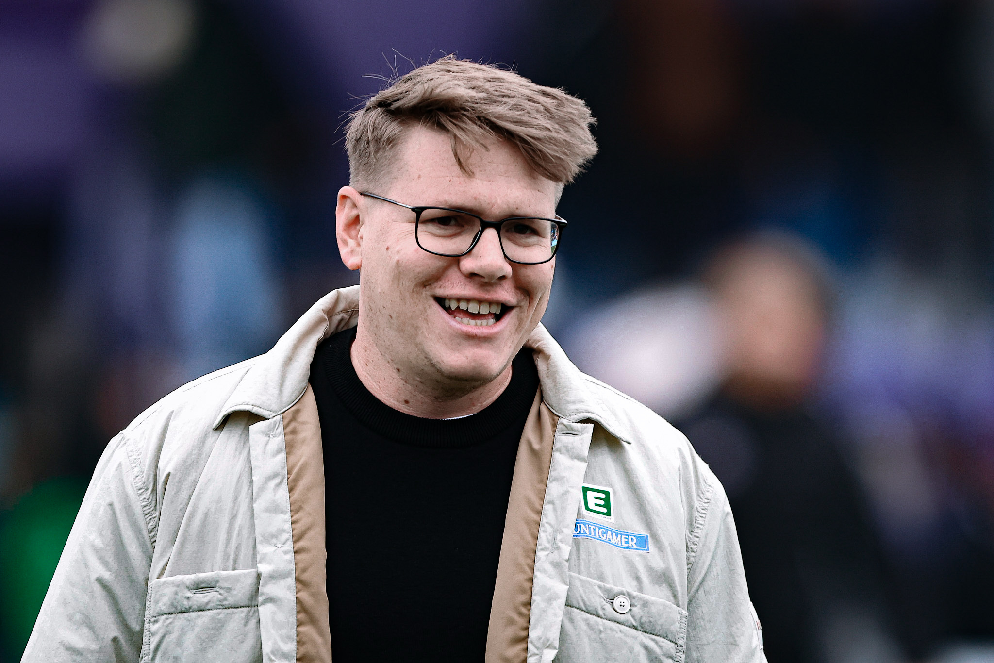 Ein Mann in Jacke lächelt.