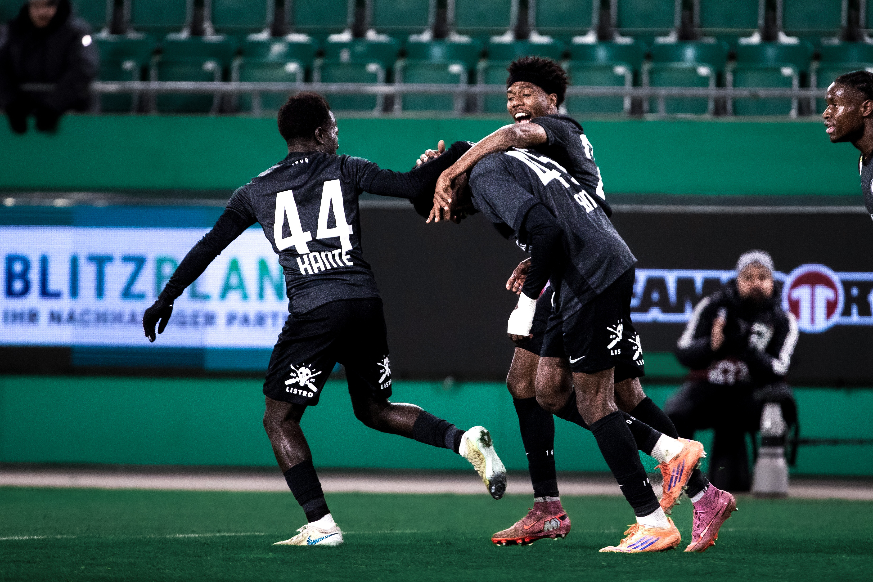 Drei Fußaller jubeln.