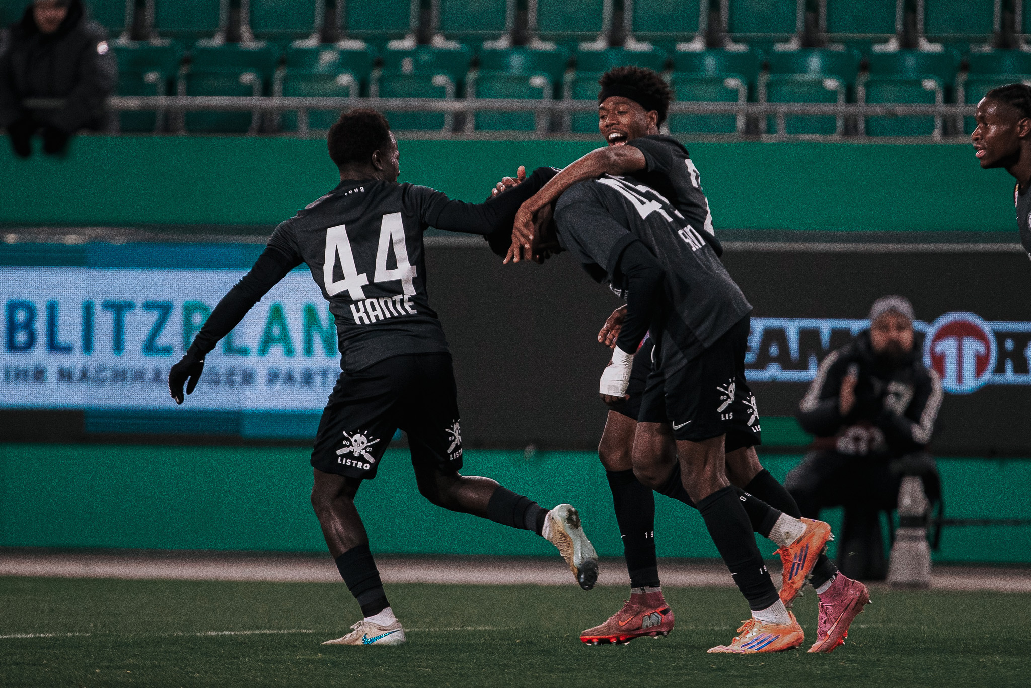 Drei Fußaller jubeln.