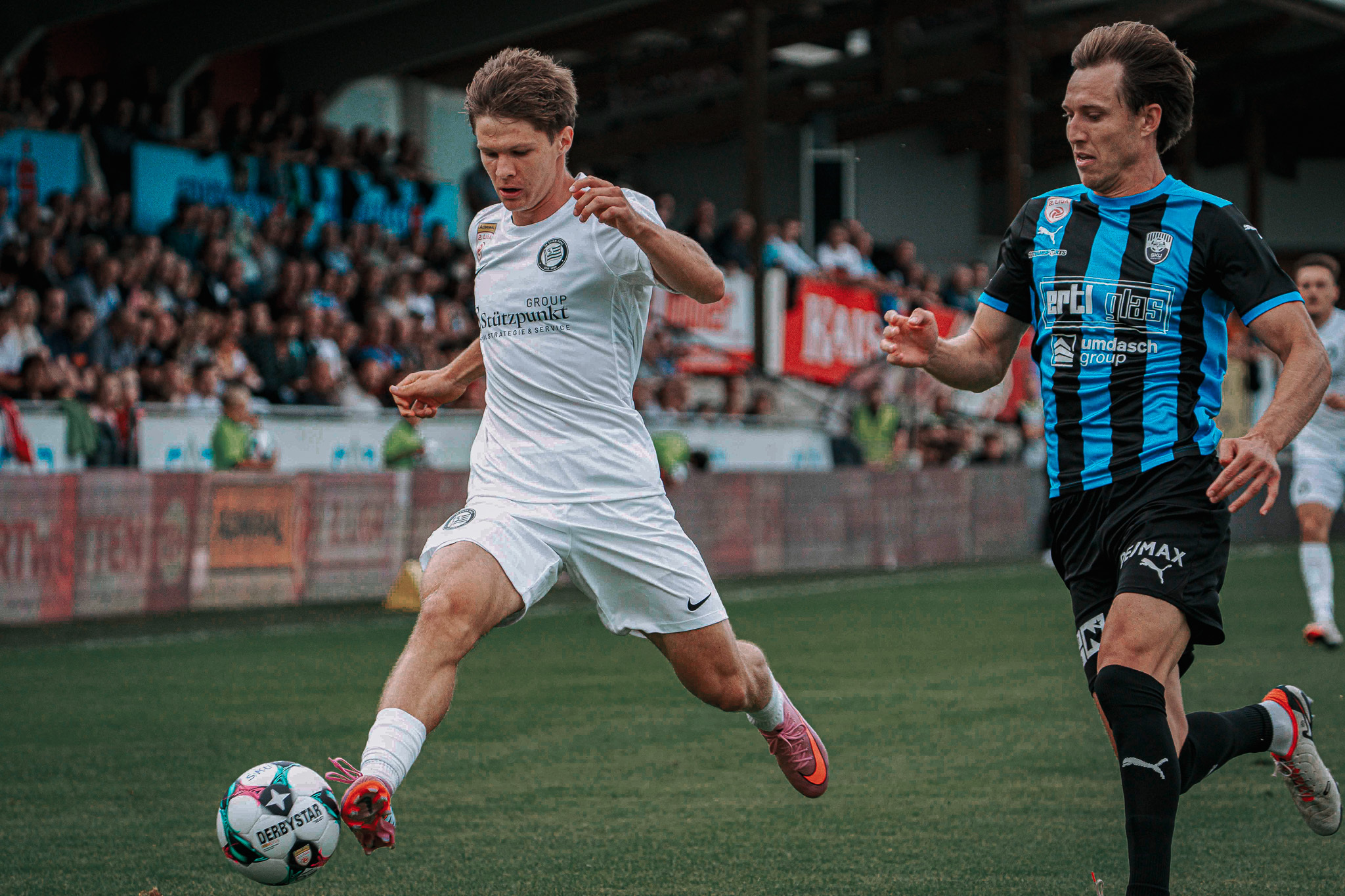 Zwei Männer spielen Fußball.