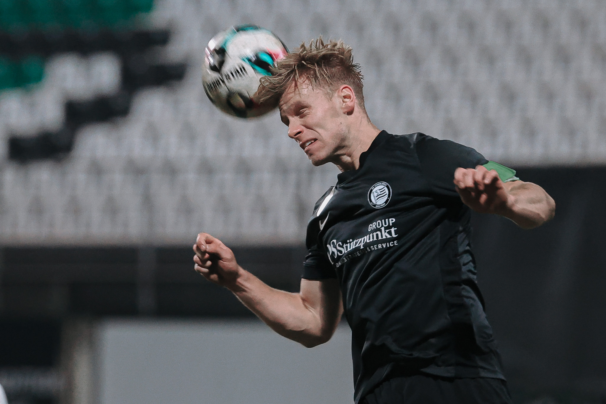 Ein Fußballer spielt den Ball per Kopf.