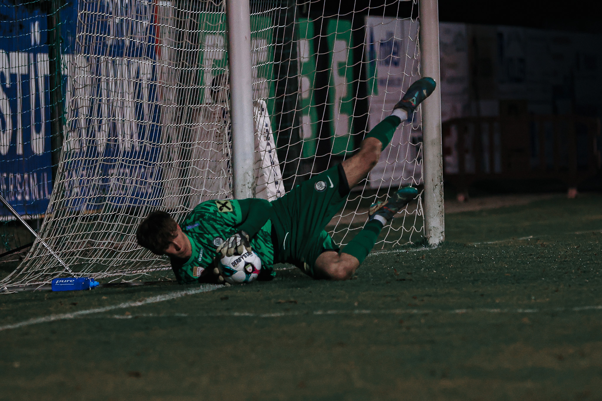 Ein Tormann hält den Ball.