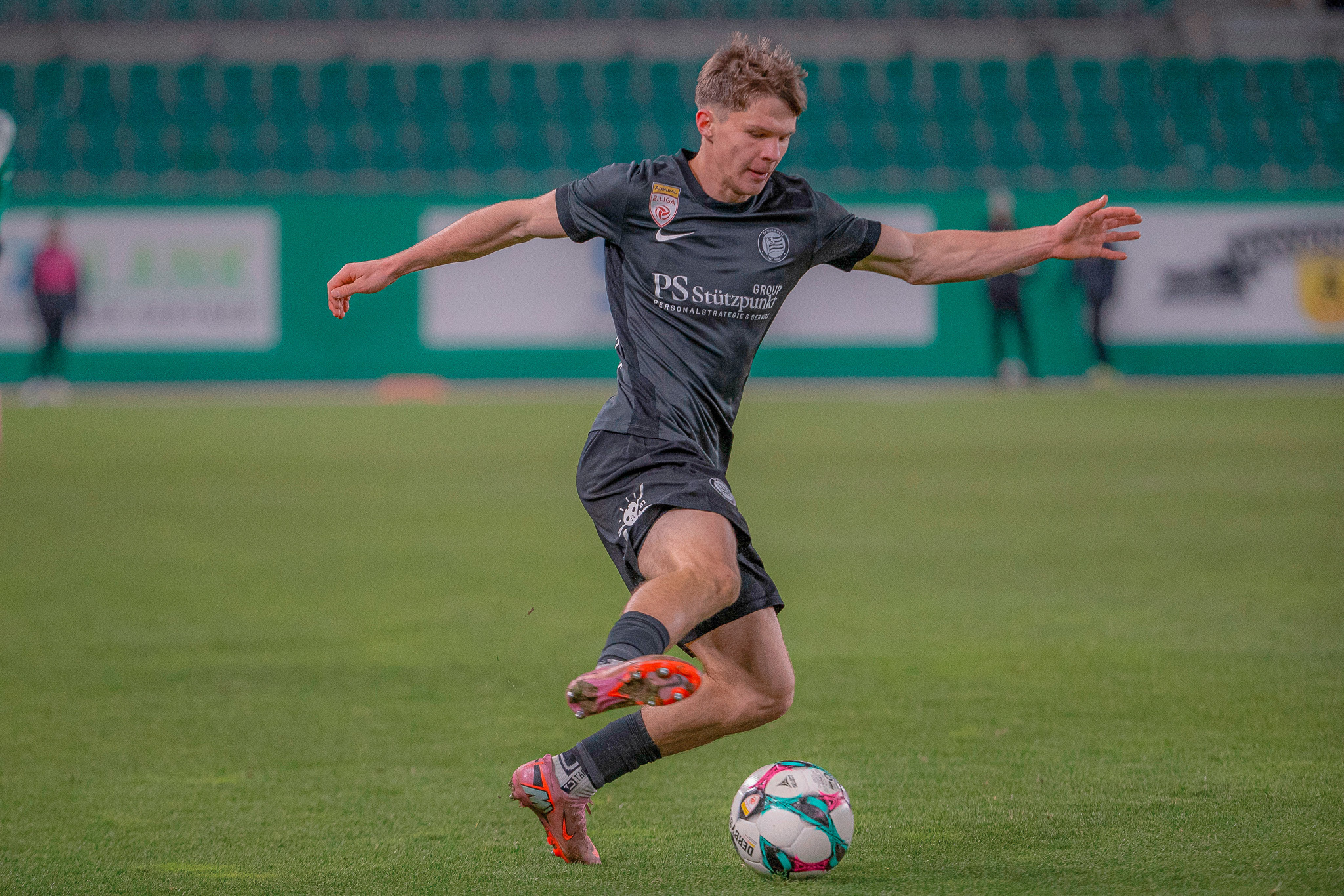 Ein Mann spielt Fußball in einem Stadion.