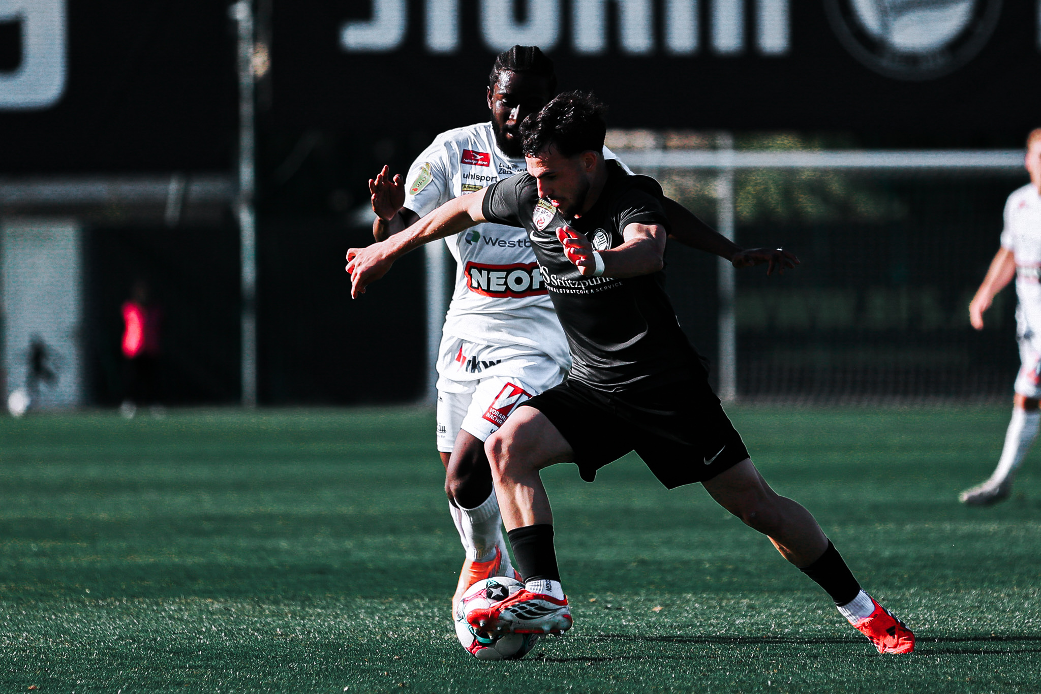 Zwei Fußballer kämpfen um einen Ball.