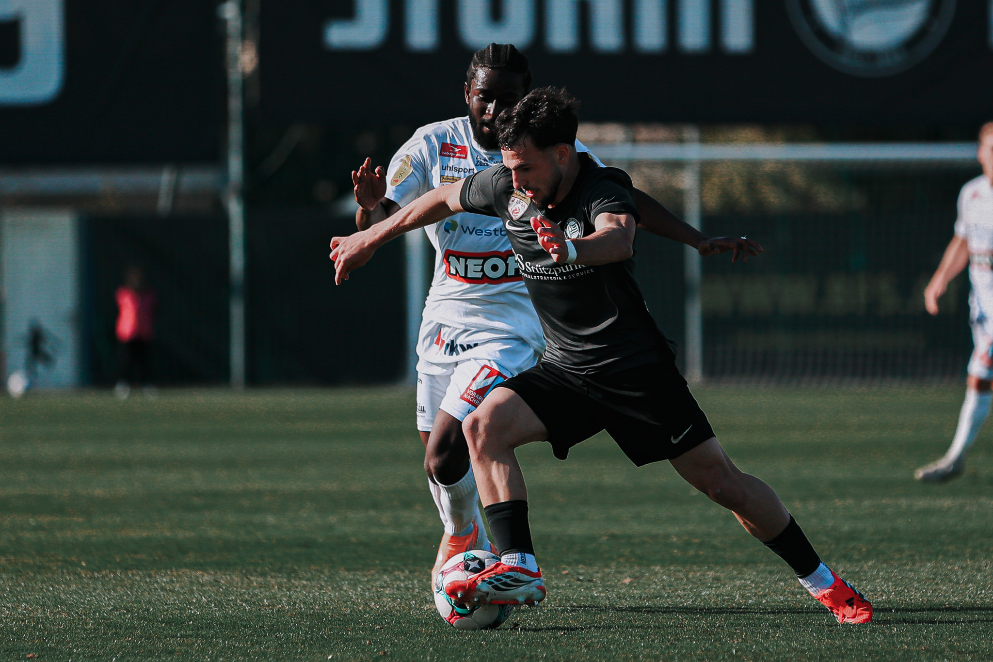 Zwei Fußballer kämpfen um einen Ball.
