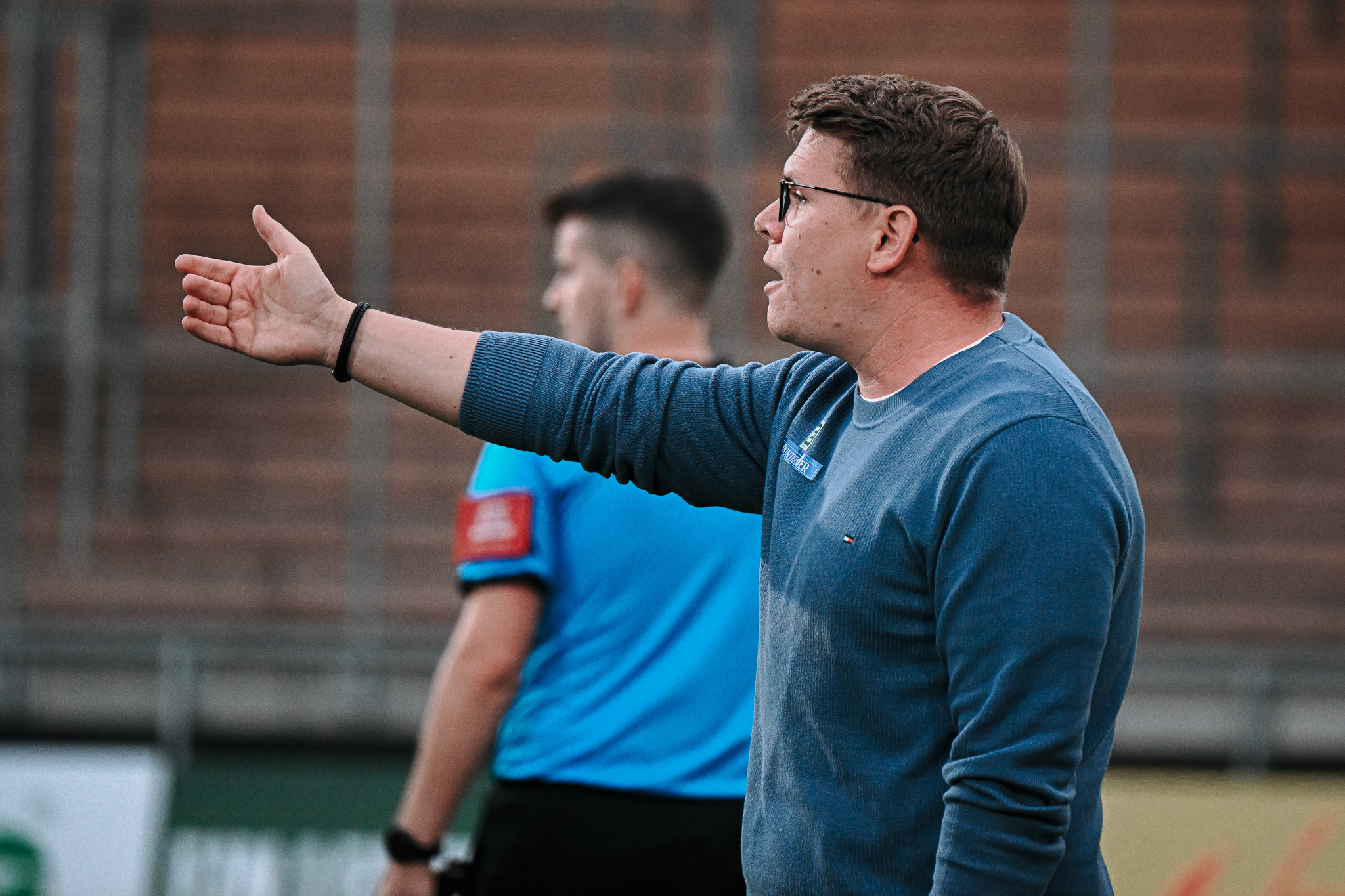 Ein Mann hebt den rechten Arm.