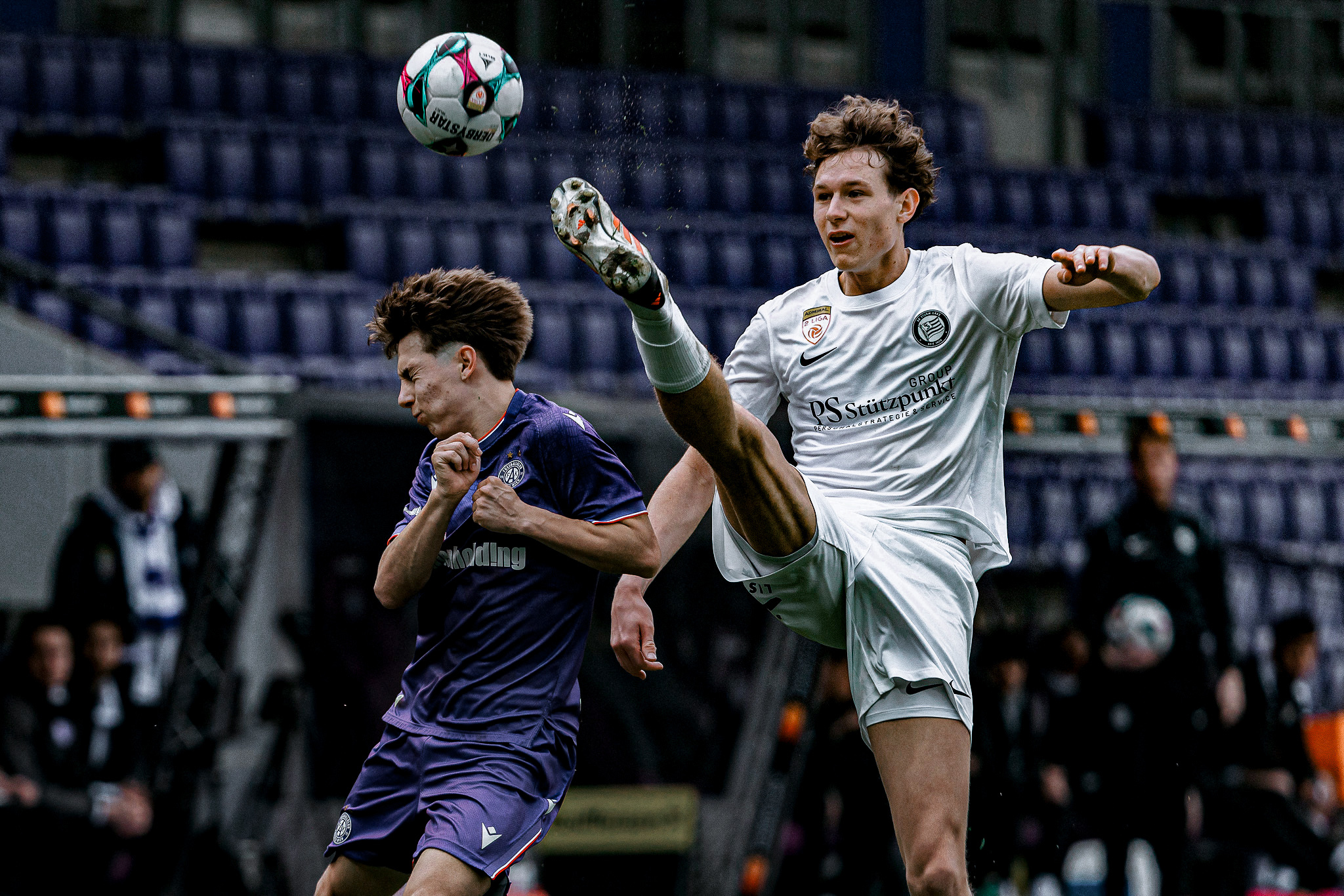 Zwei Männer spielen Fußball.